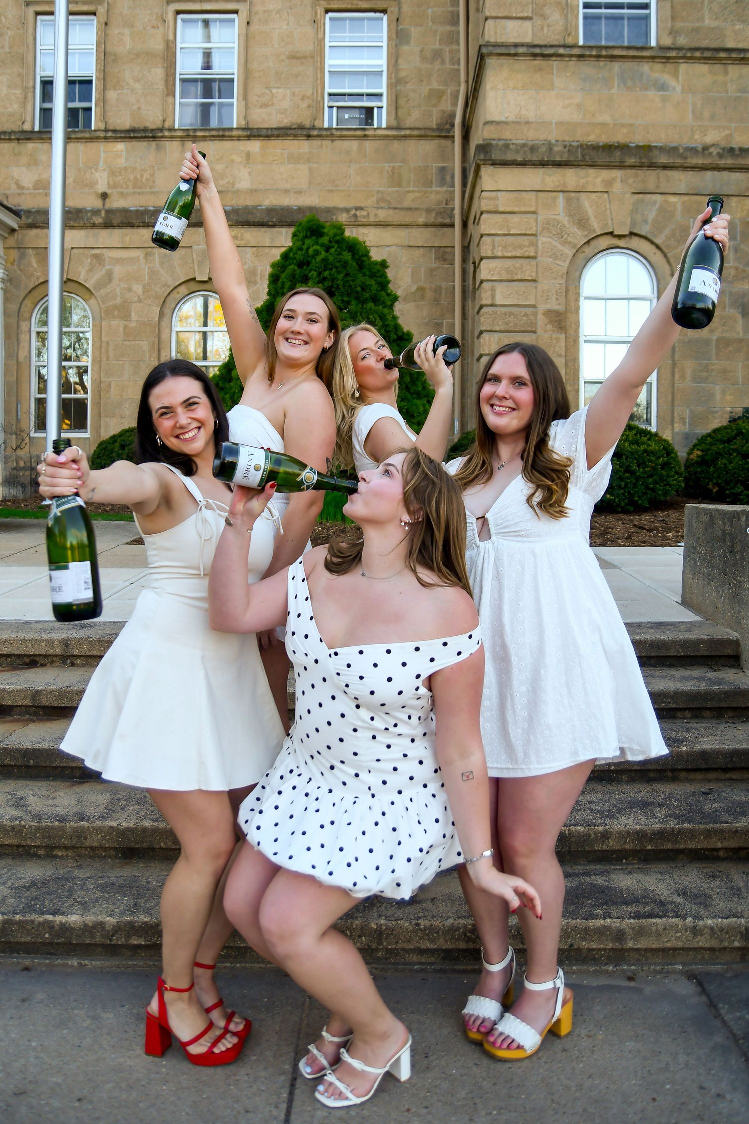 A group of girls holding champagne bottles.