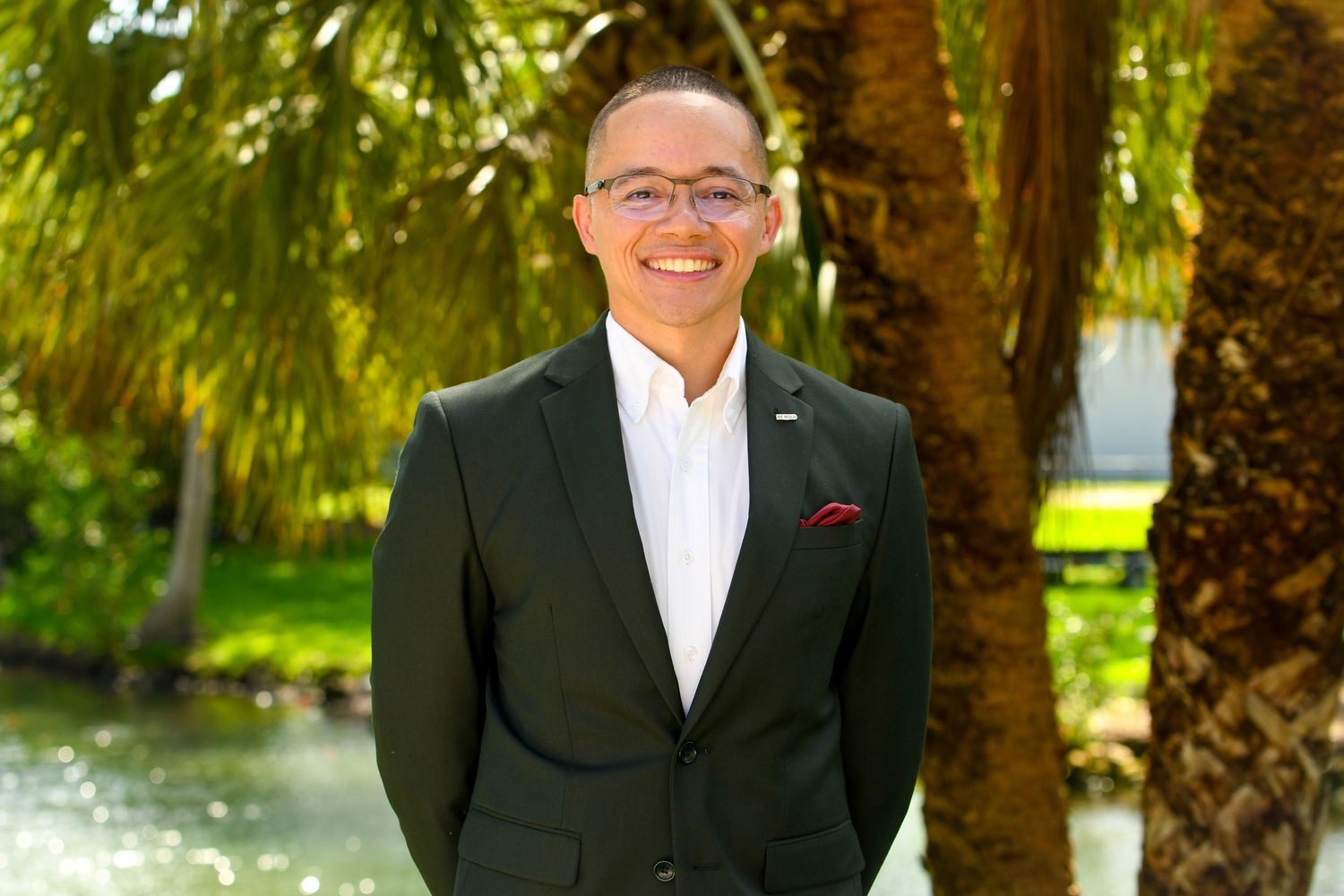 Man smiling surrounded by palm trees