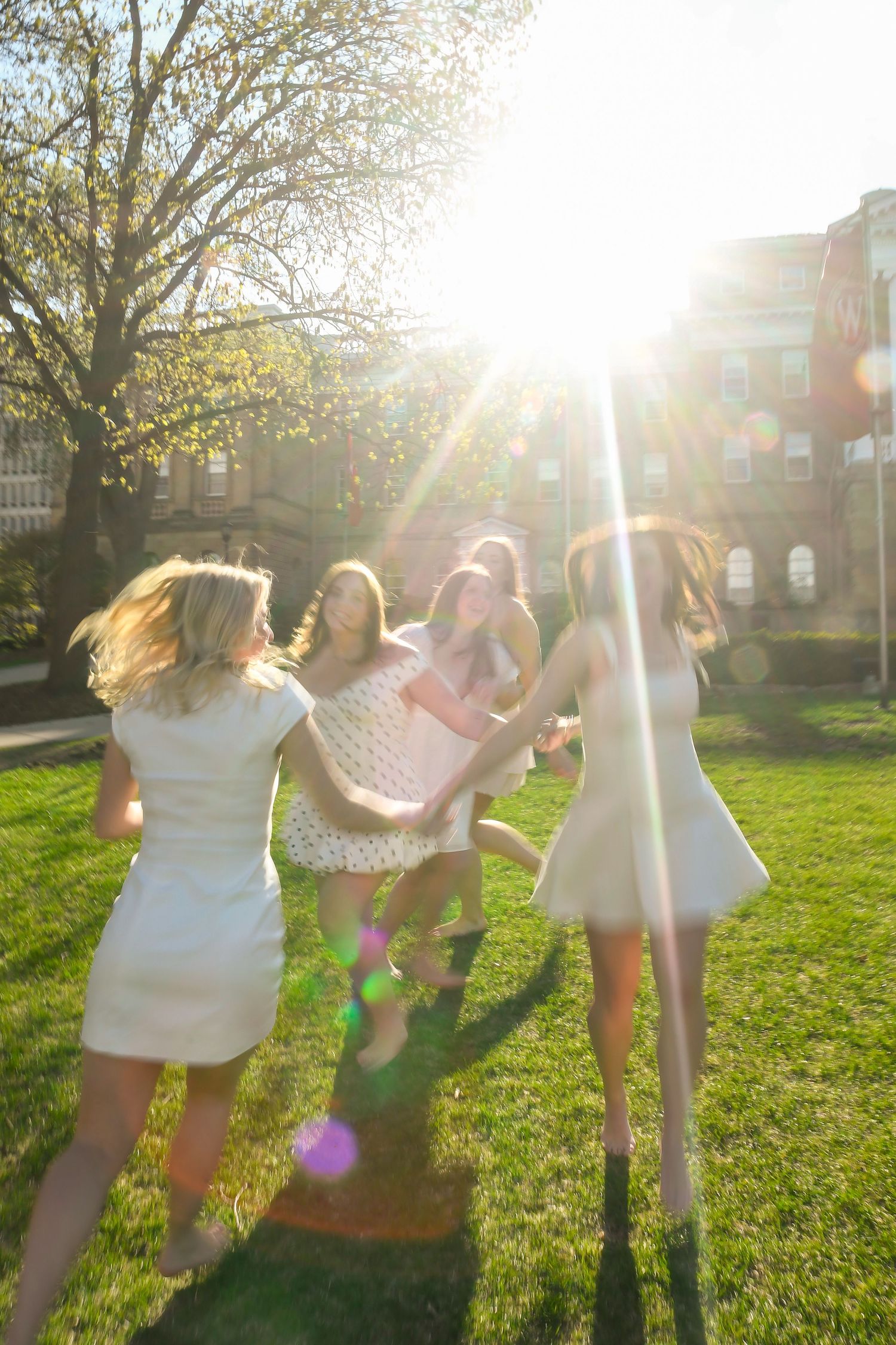 Girls gallivanting in a field during sunset.