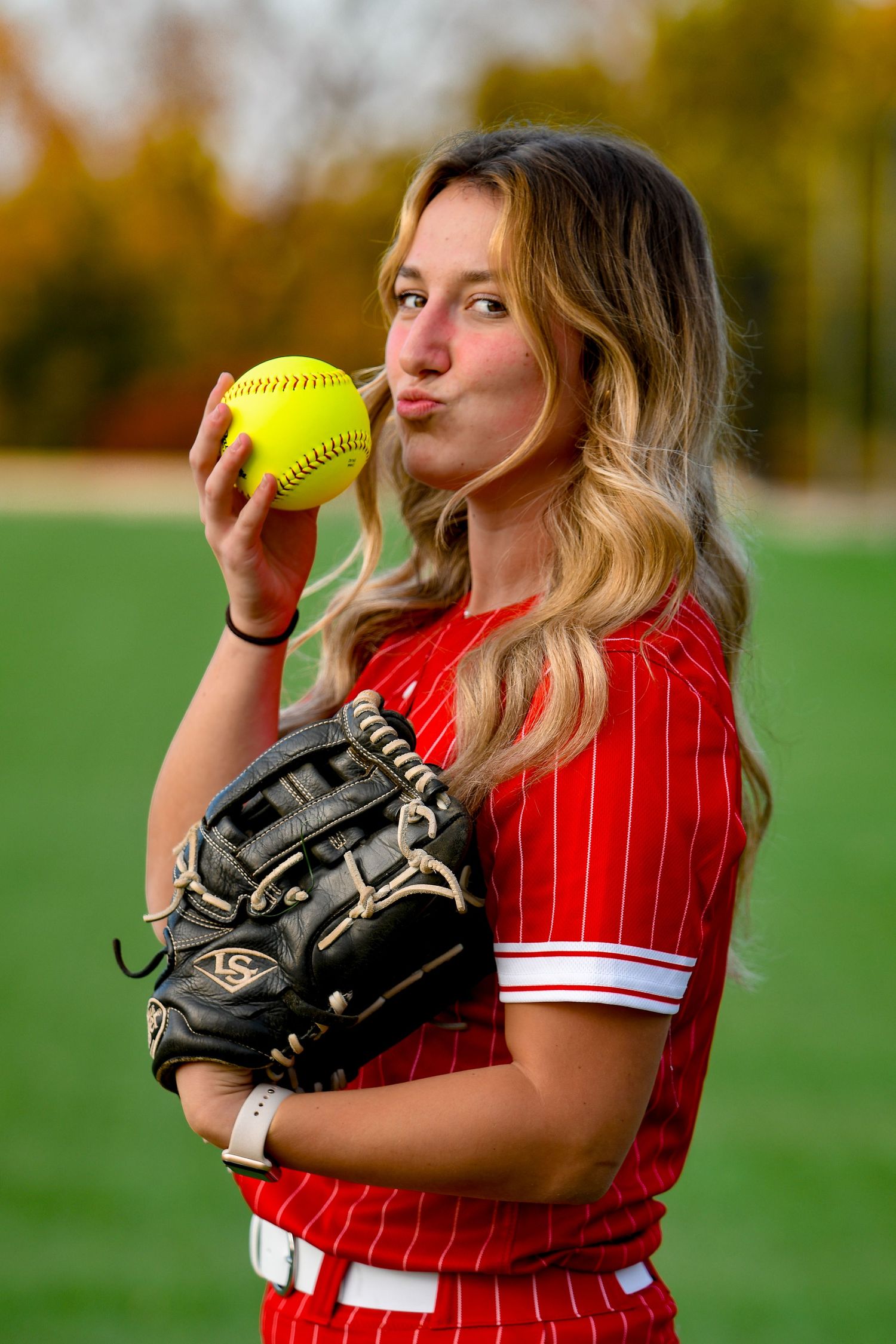 Girl smiling and kissing a softball