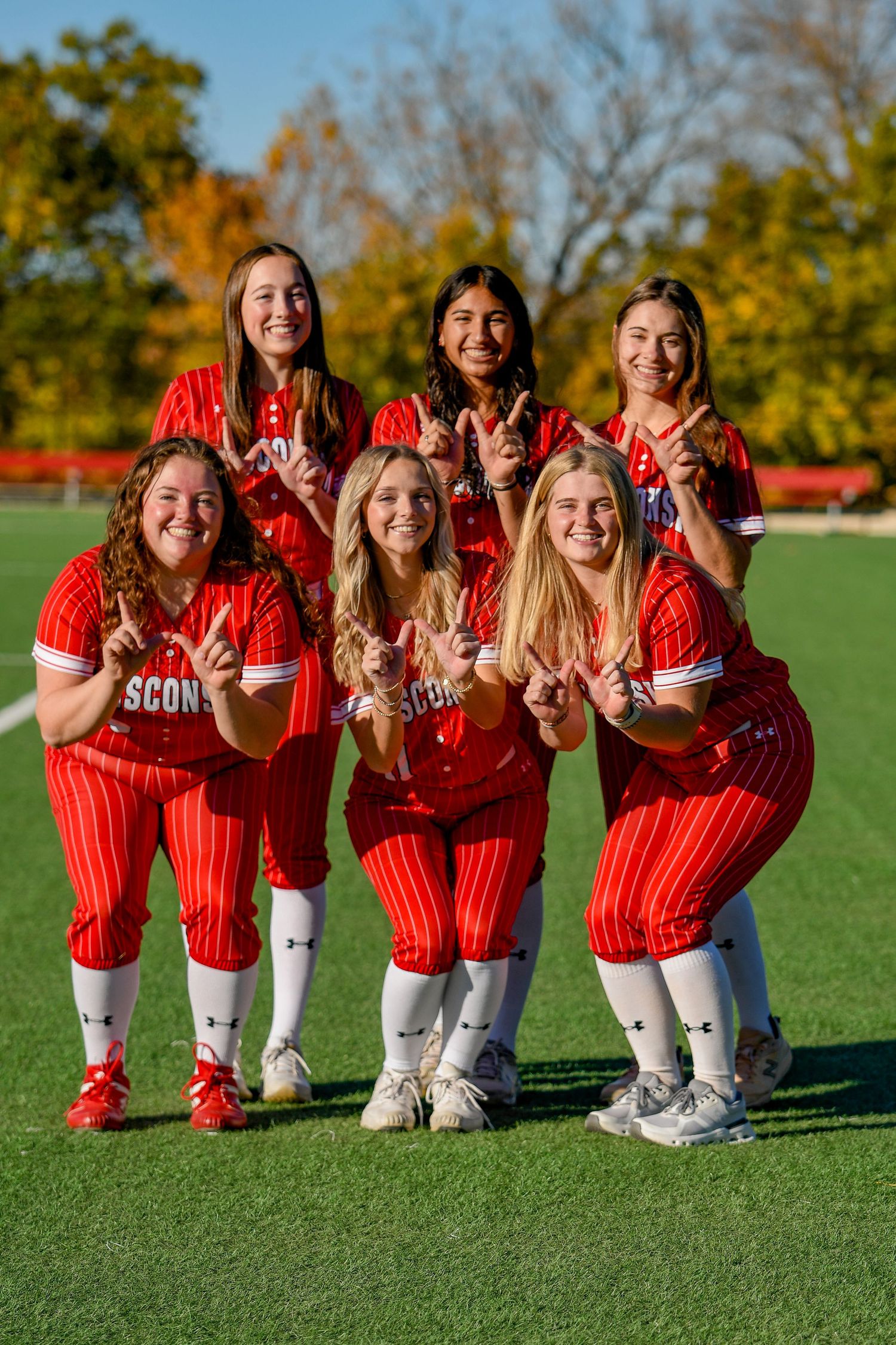 Six girls smiling and holding up 