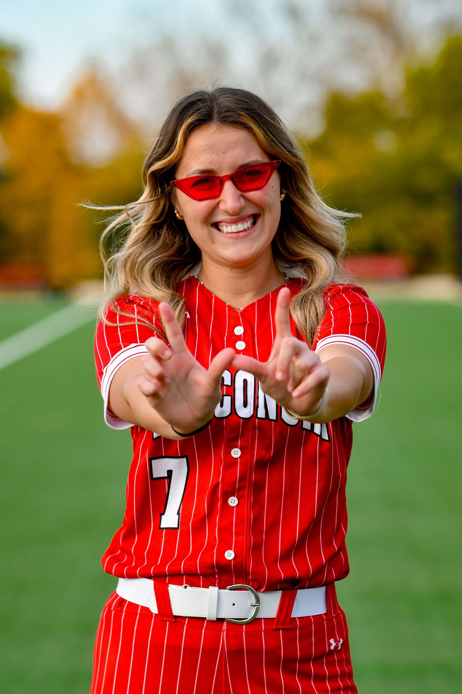 Girl smiling in fun sunglasses holding up a 