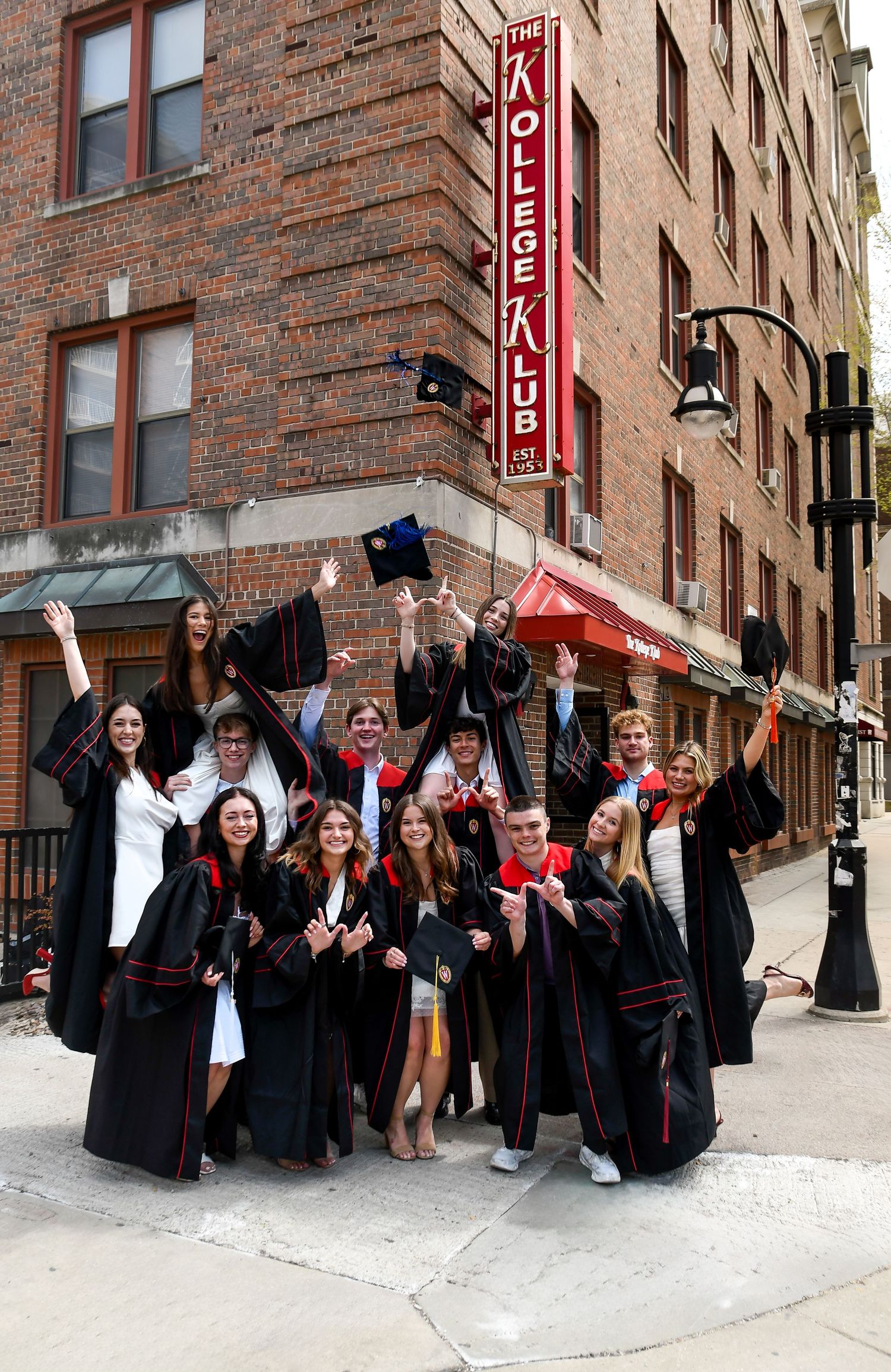 Group of graduates smiling and throwing caps