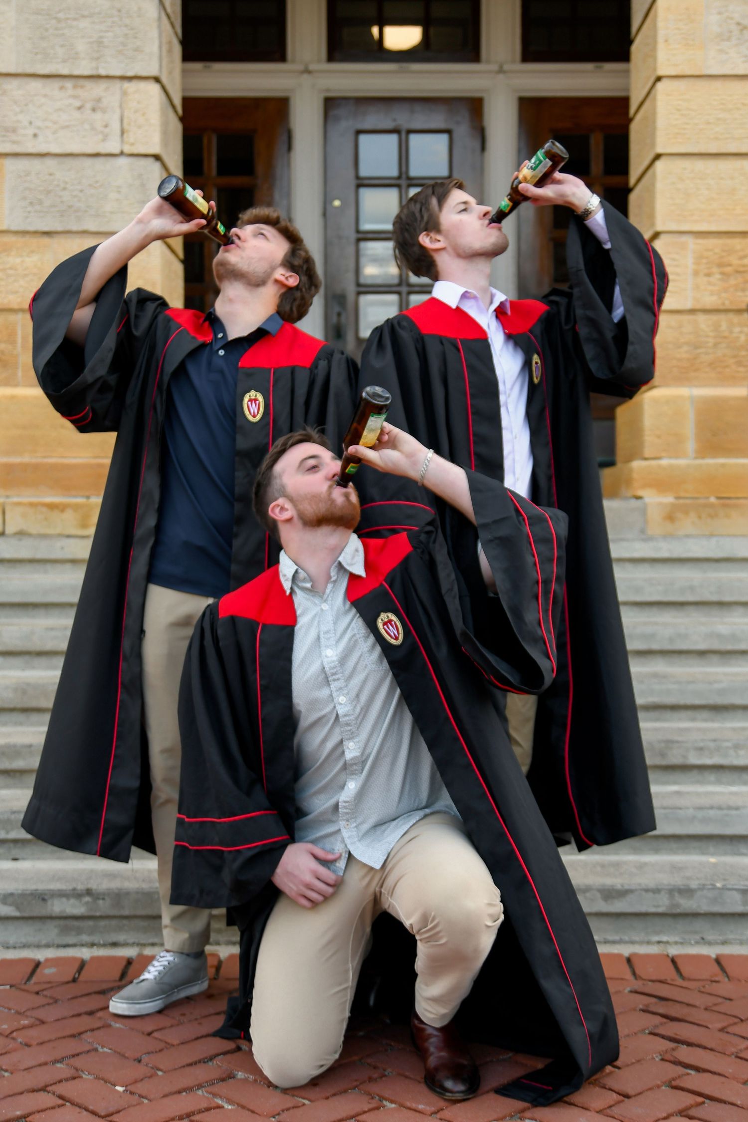 Three male graduates drinking beers