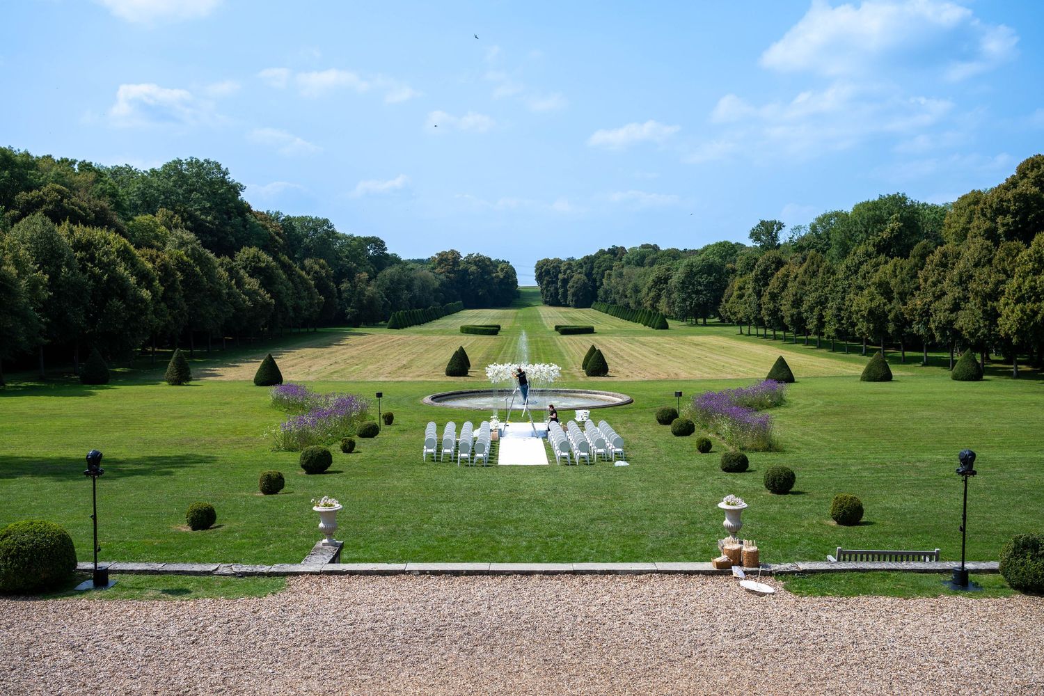 Sweeping aerial view of a formal garden with symmetrical hedges and water features.