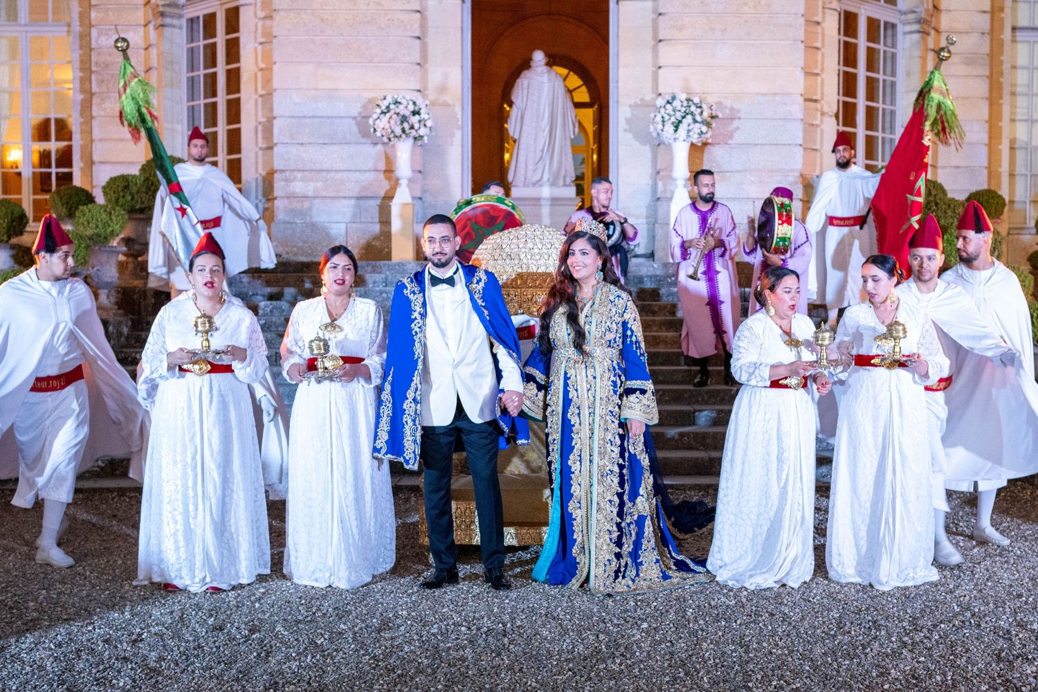 A group in traditional period costumes poses on grand stone steps during a historical reenactment event.