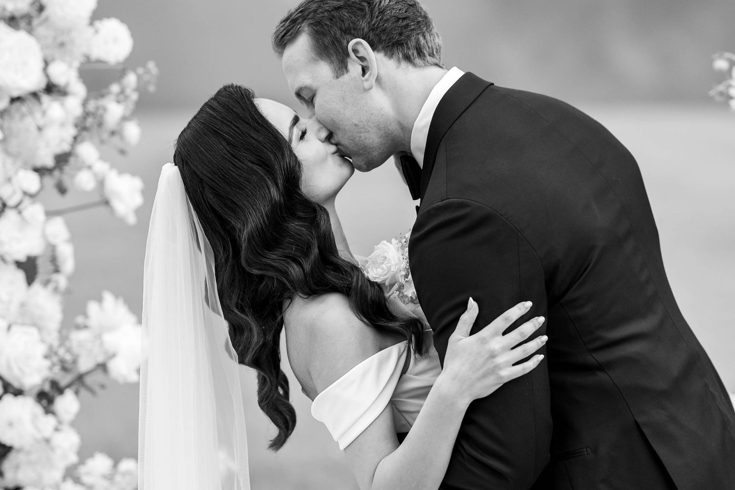 A black and white collage of romantic wedding photos showing couples embracing and kissing.