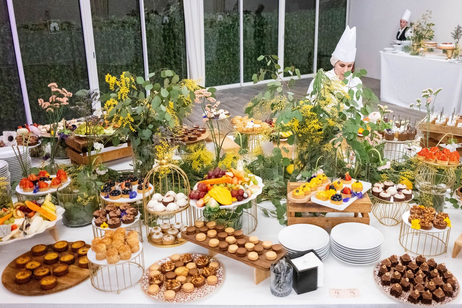 Luxurious dessert and appetizer buffet table with various sweets and snacks beautifully displayed.