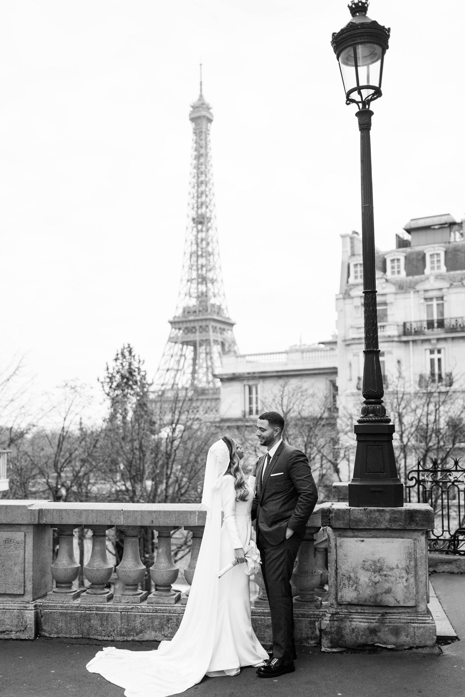 Romantic wedding photos taken near the Eiffel Tower in Paris with elegant couple and vintage street lamps.