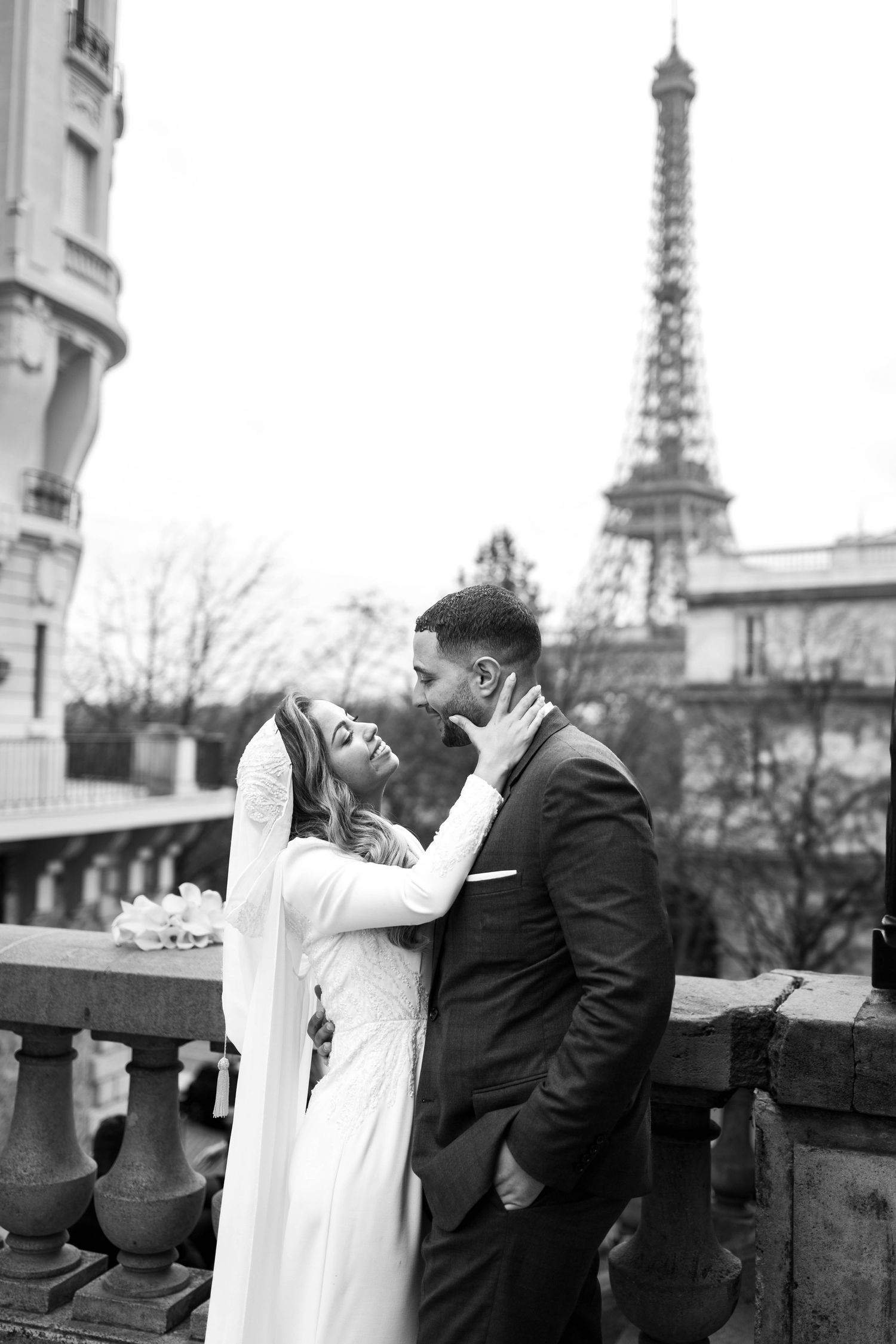 Intimate wedding moment captured in black and white with Paris cityscape in background.