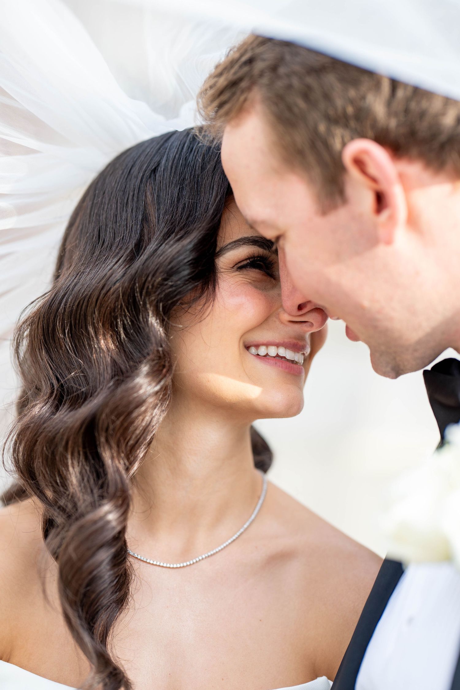 A romantic close-up shot of a couple in wedding attire sharing an intimate moment together.