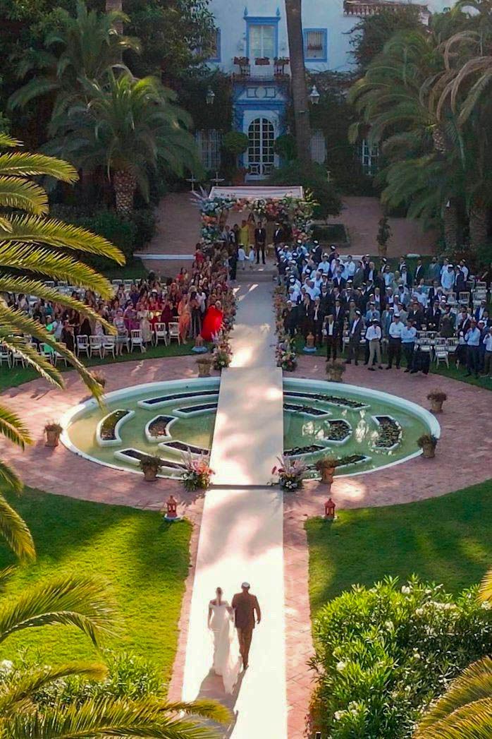 Outdoor amphitheater ceremony space surrounded by palm trees and lush gardens.