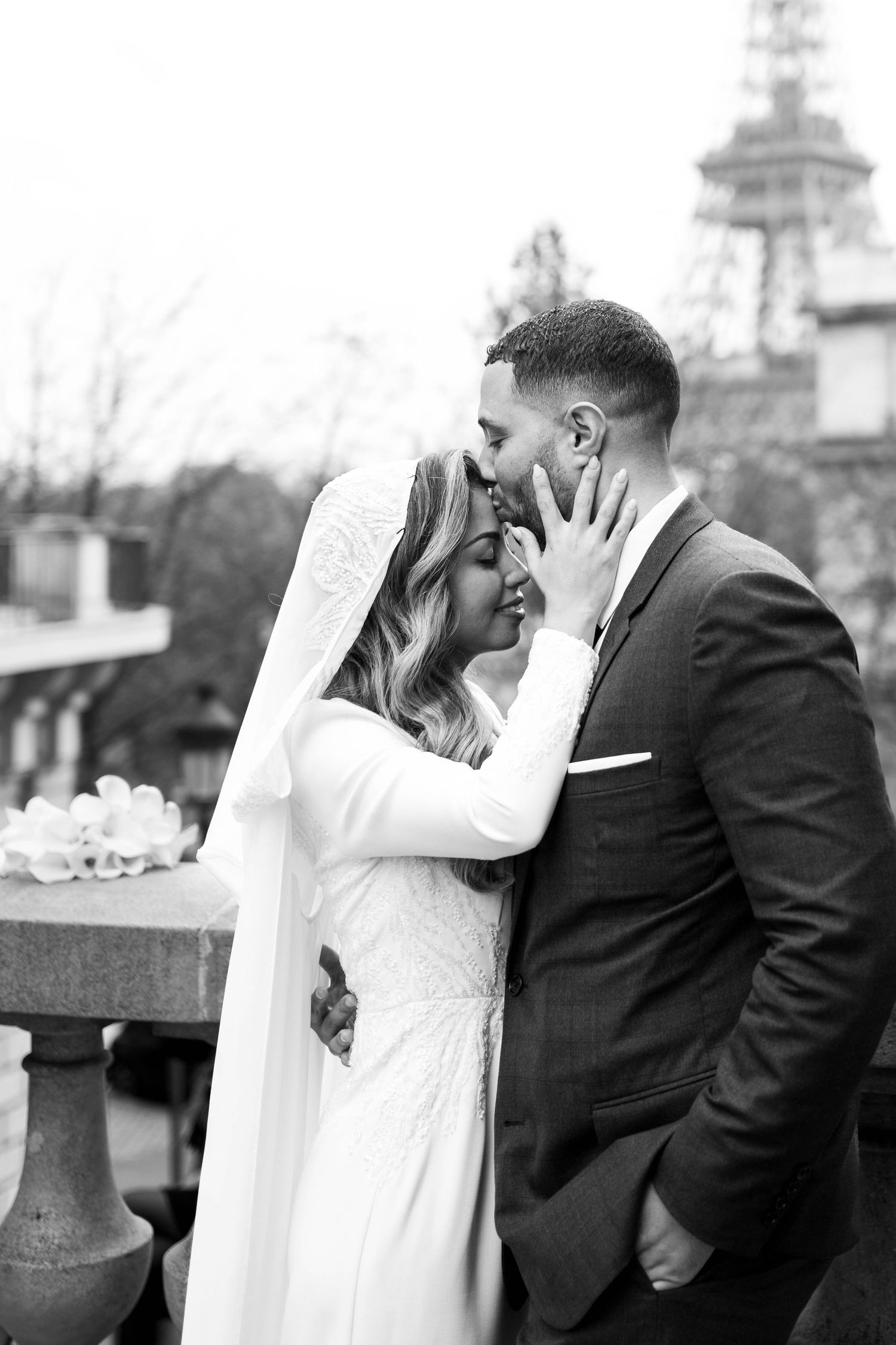 A series of black and white wedding photos showing a couple sharing romantic kisses outdoors.