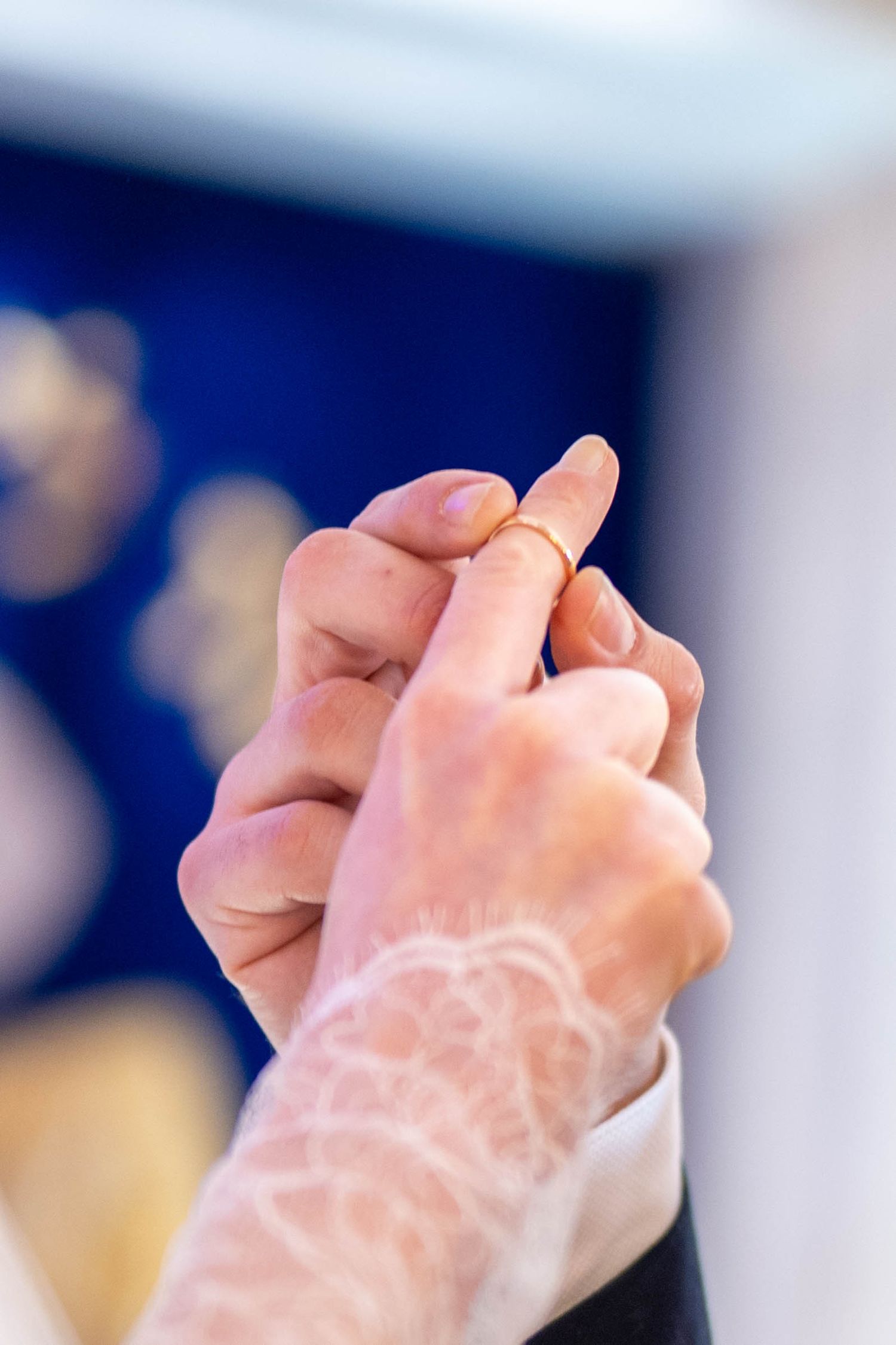 Close-up detail of hands with wedding rings during traditional Jewish ceremony.