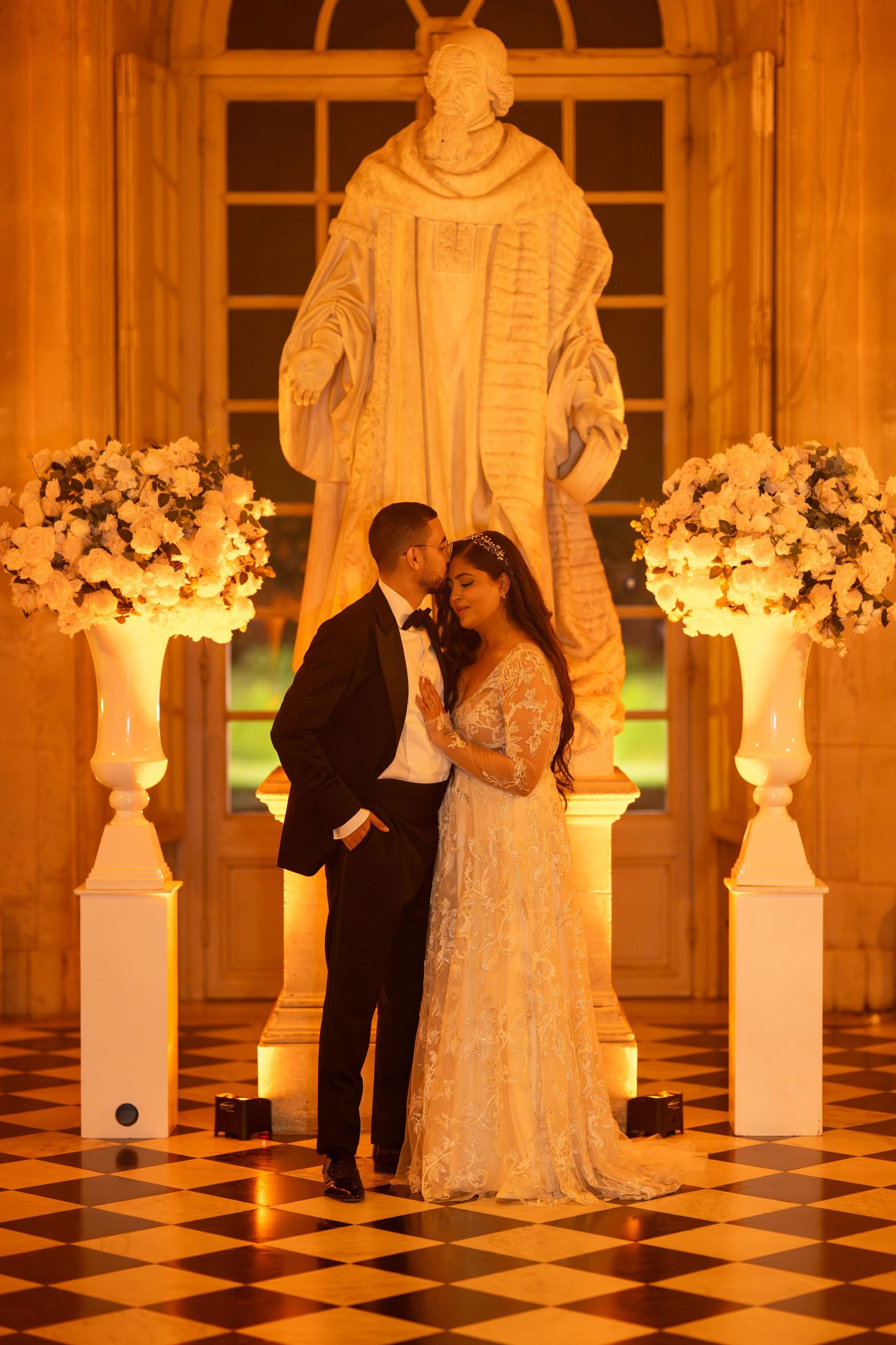 Elegant ballroom scene with white floral arrangements and warm lighting creating a romantic atmosphere.