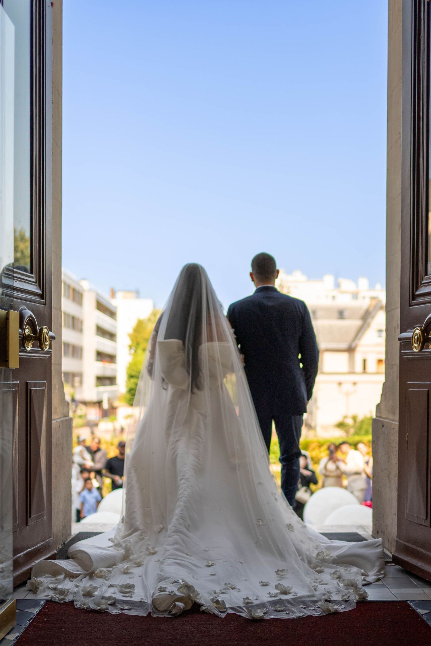 A sequence of four photos showing a bride and groom silhouetted in a doorway with flowing white veil trailing behind.