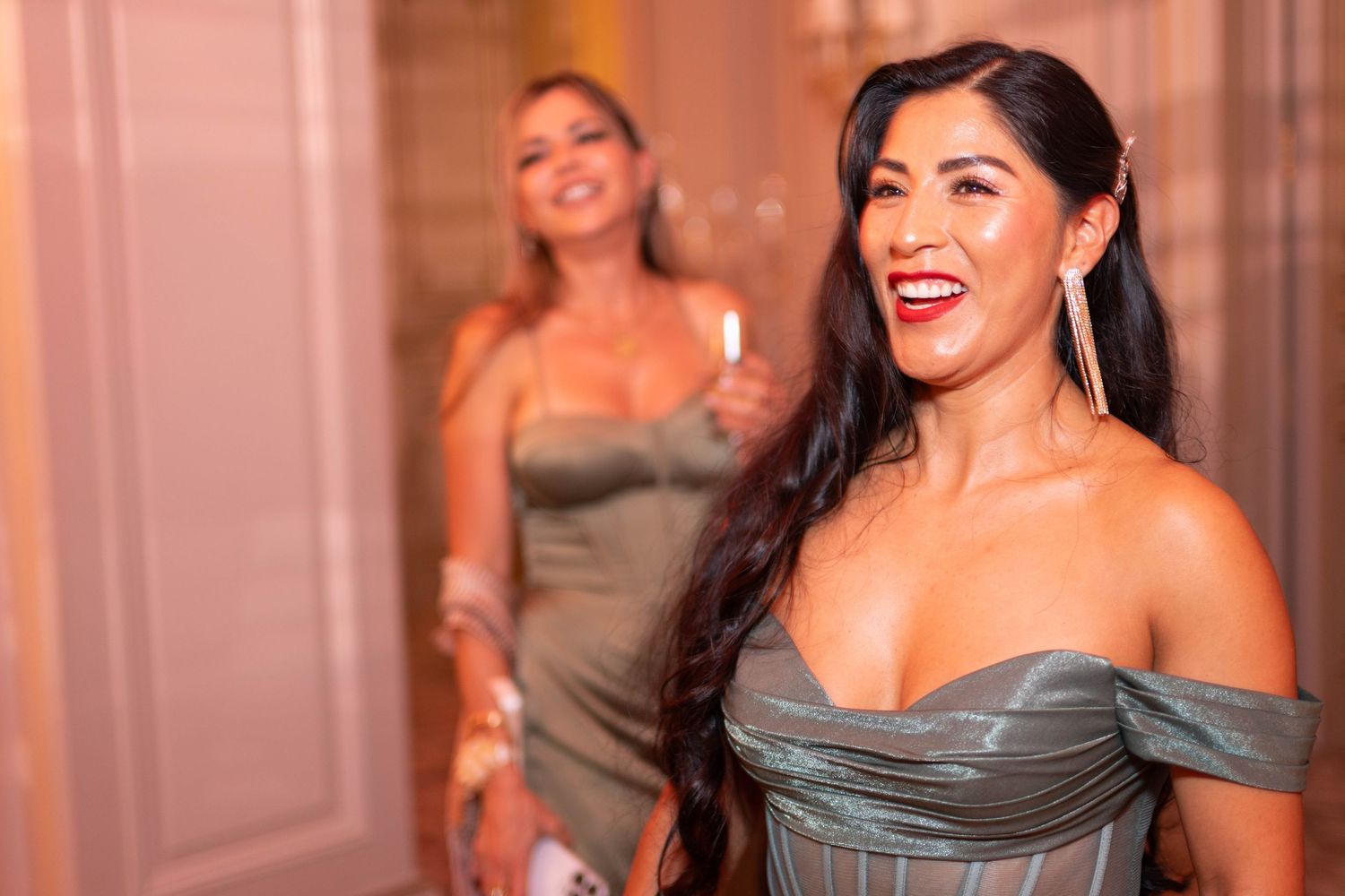 A group of bridesmaids in elegant gray off-shoulder dresses pose together at a formal wedding event.