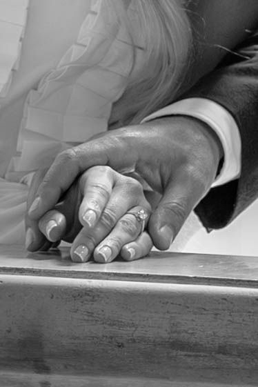 Close-up black and white images showing hands writing or drawing on paper against a wooden surface.