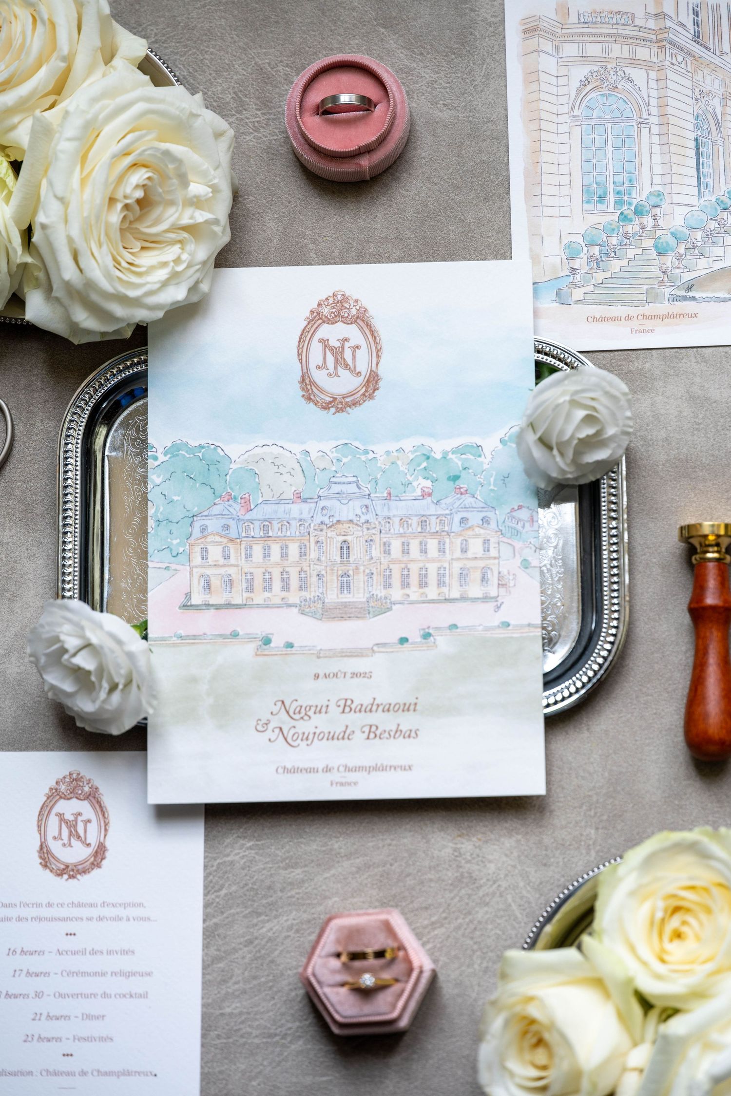 Elegant wedding invitation suite with white roses and ornate palace illustrations in soft blue tones.