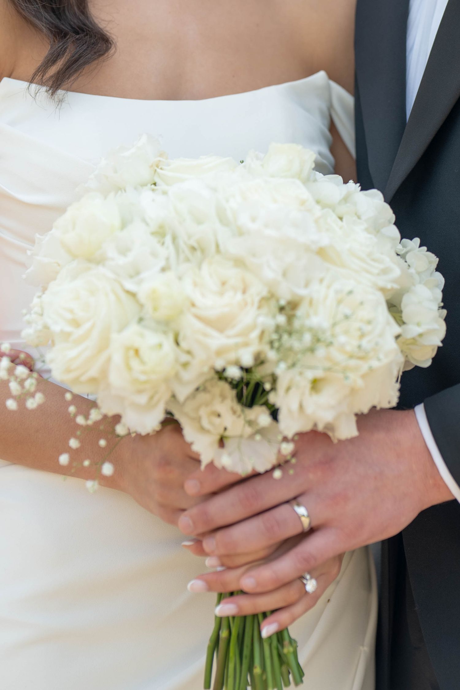 A series of wedding photos showing white floral bouquets held against a white dress and dark suit.