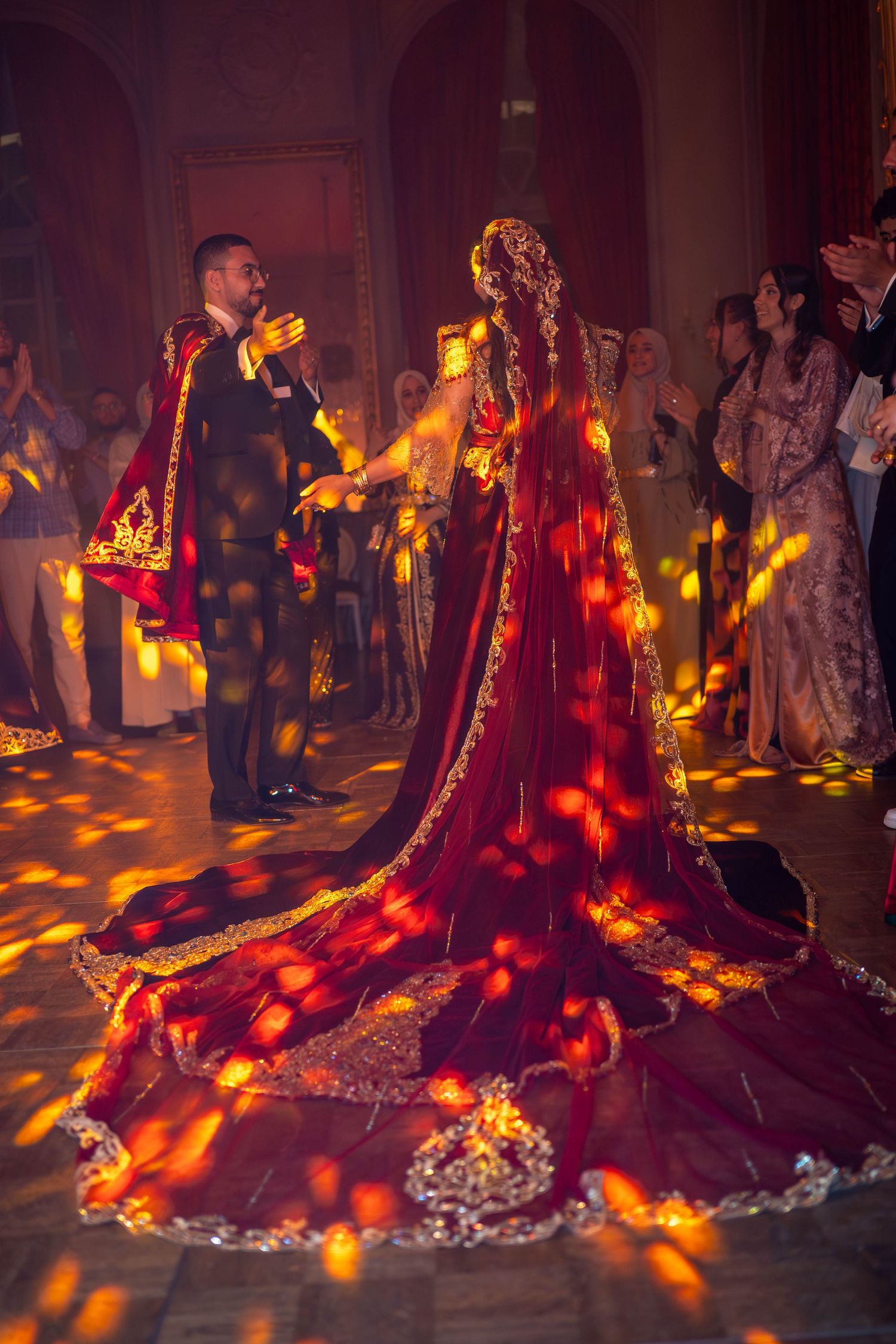 Wedding dress train illuminated by dramatic red and orange lighting on a checkered floor.