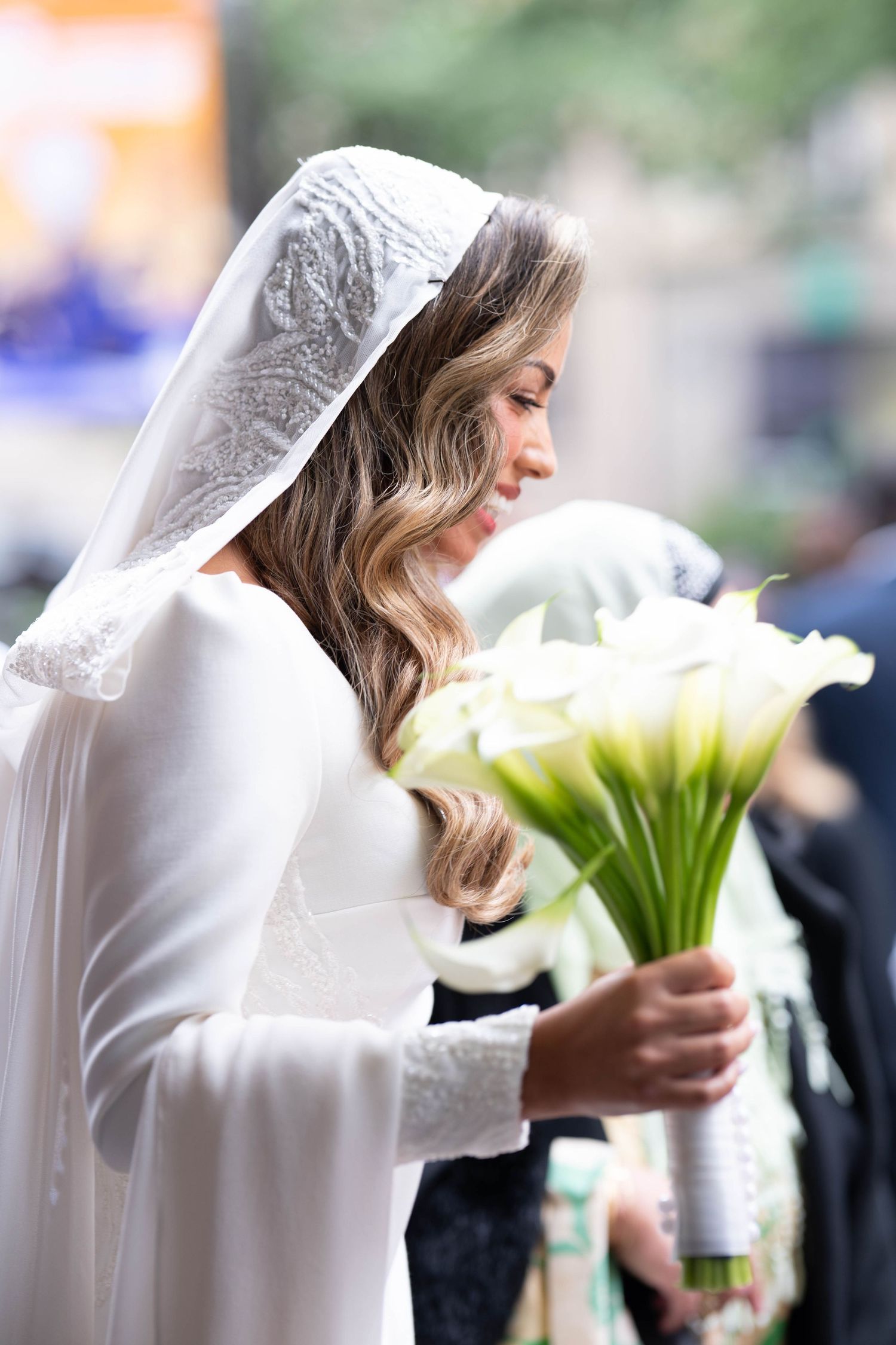 A bride in a white veil holds a bouquet of calla lilies in a series of artistic wedding photographs.