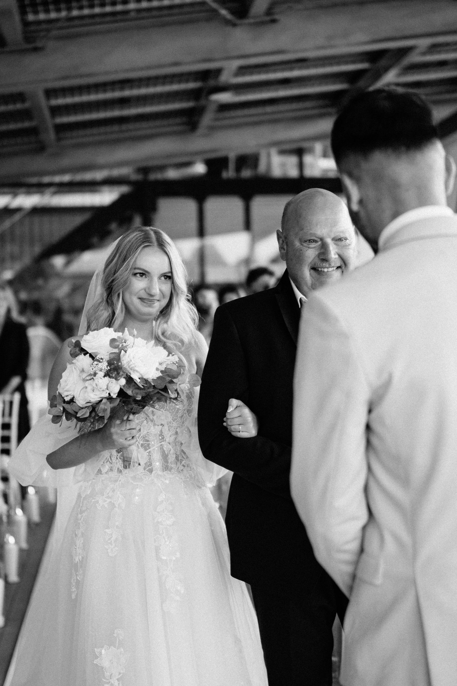 Black and white wedding ceremony moments captured under an outdoor pavilion with floral details.