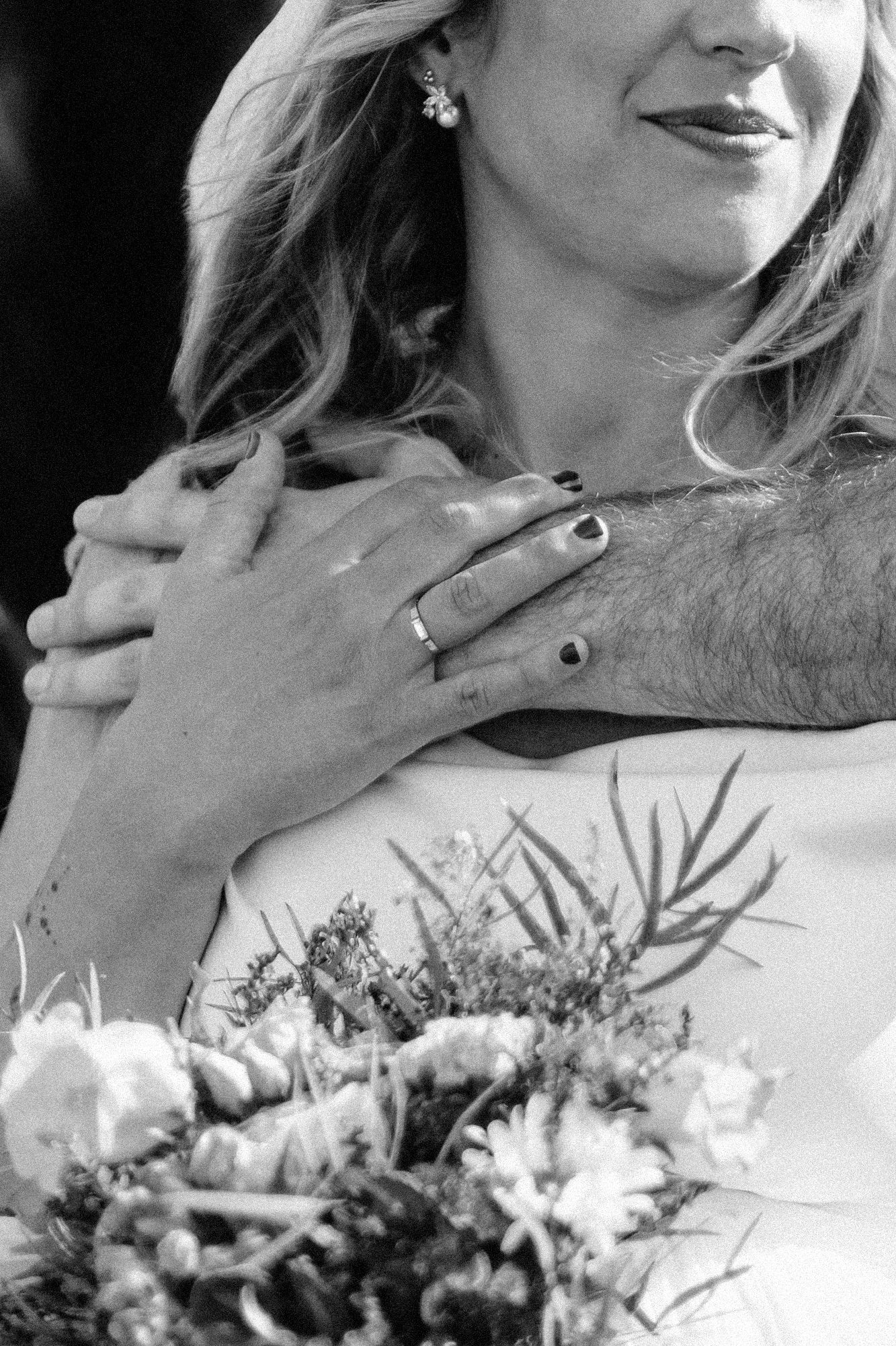 Black and white close-up of a wedding bouquet with delicate floral details.