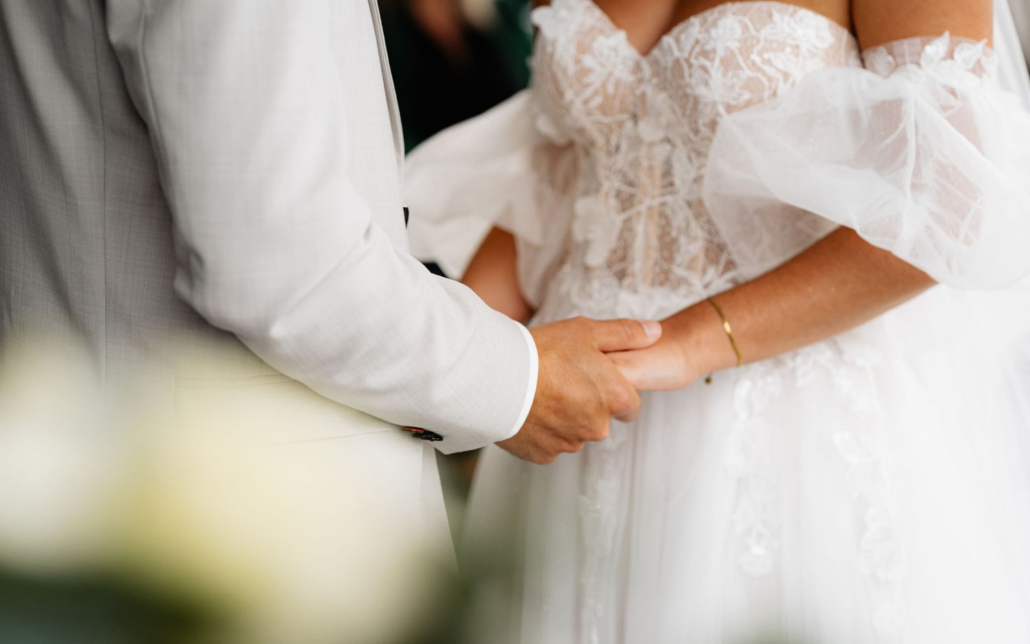 Detailed view of elegant white lace wedding dress bodice.