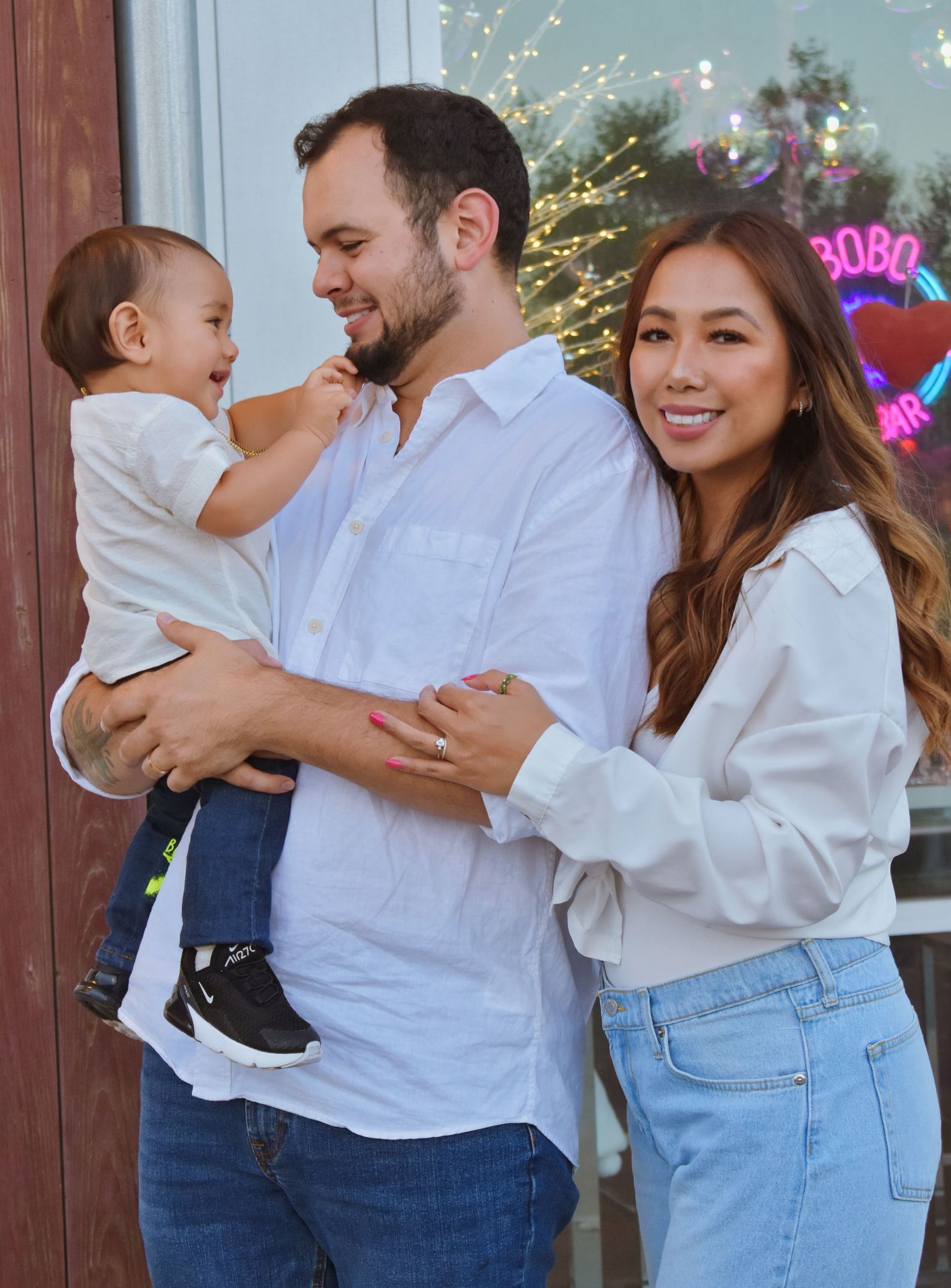 A joyful family moment captured against a backdrop of holiday lights and decorations.