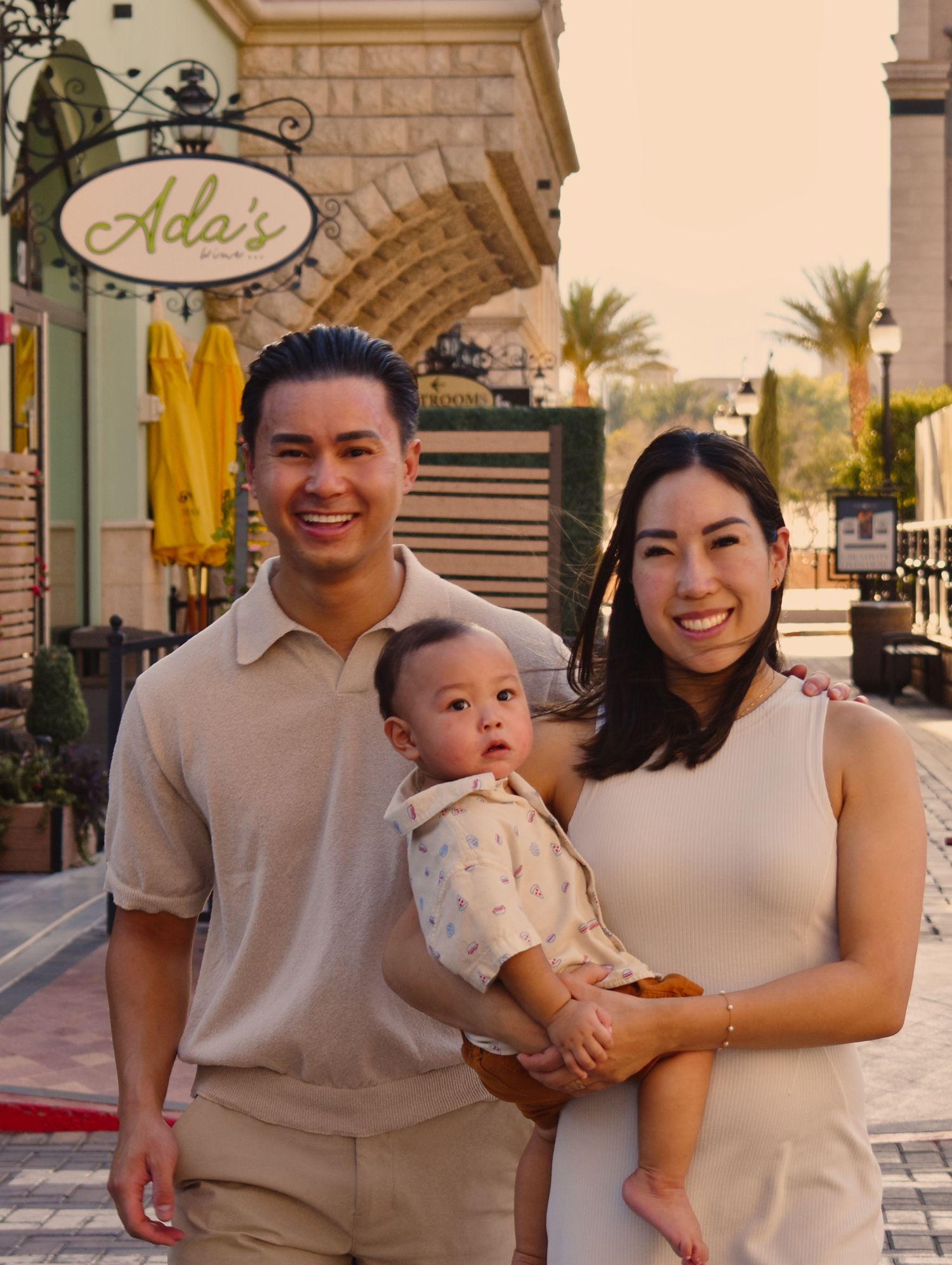 Family portrait session outside a shopping center with stone architecture.