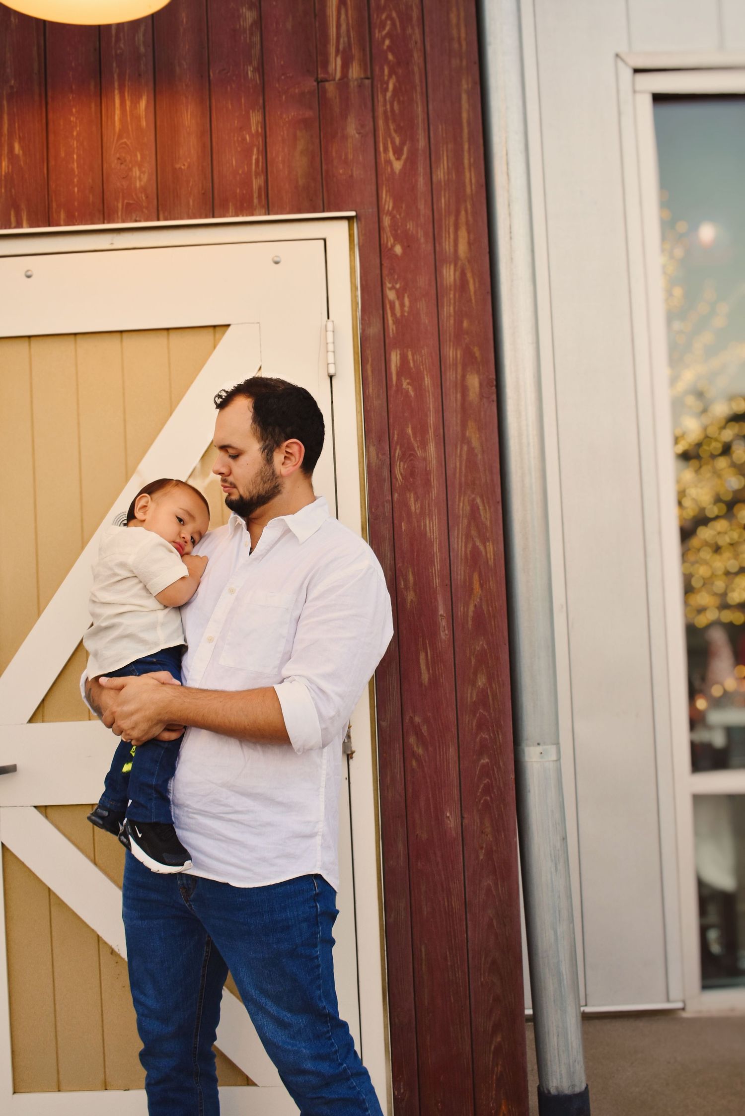 Intimate family portraits captured against a wooden wall at golden hour.