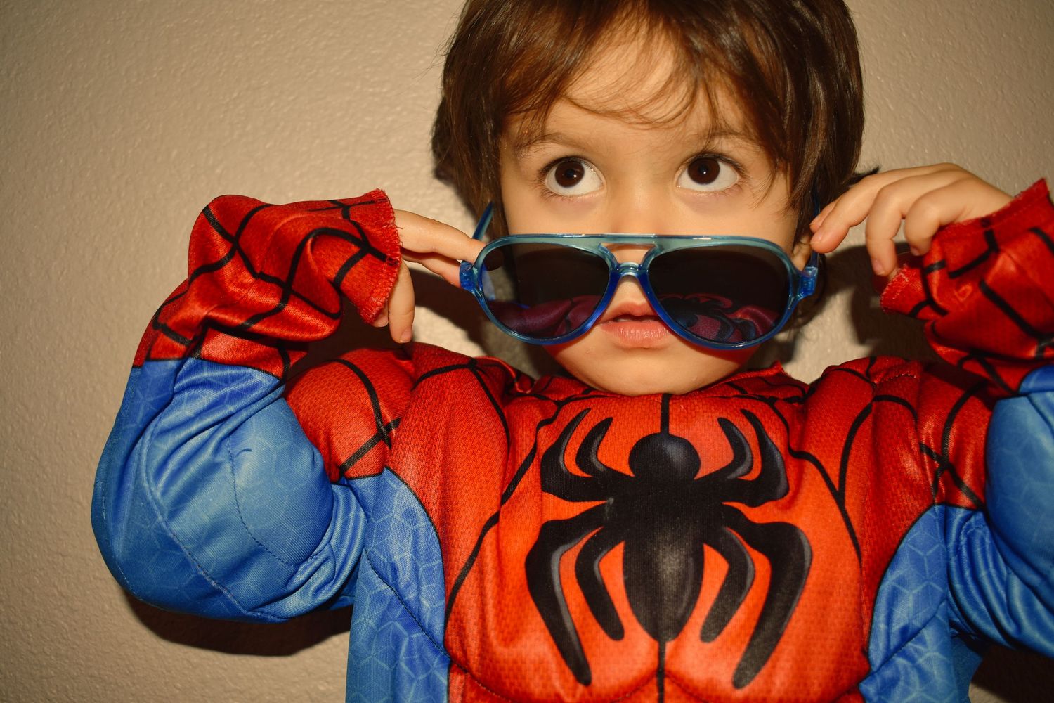 A Spider-Man costume with sunglasses and web emblem creates a playful superhero moment.