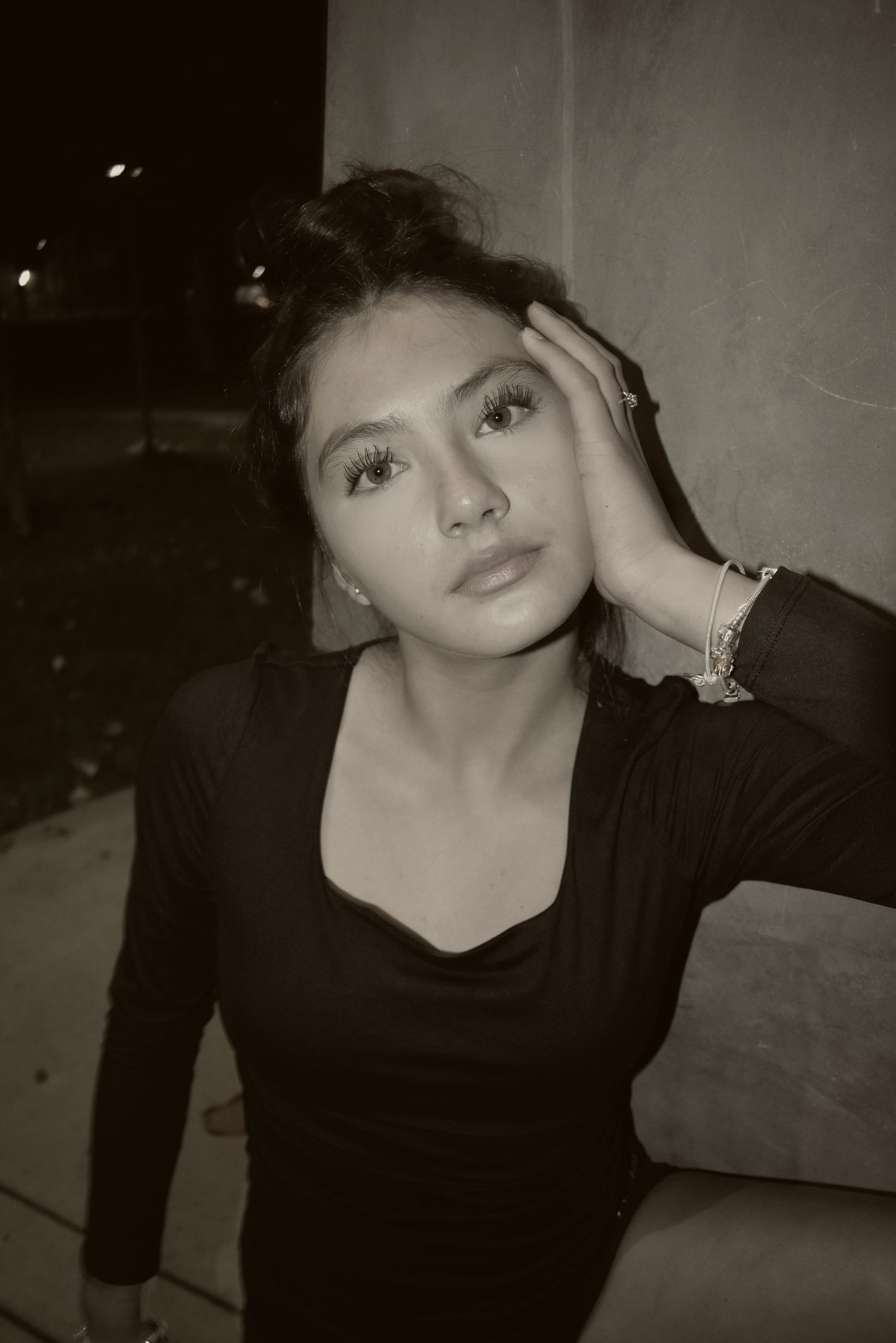 Artistic black and white portrait series showing dramatic poses against a dark background.
