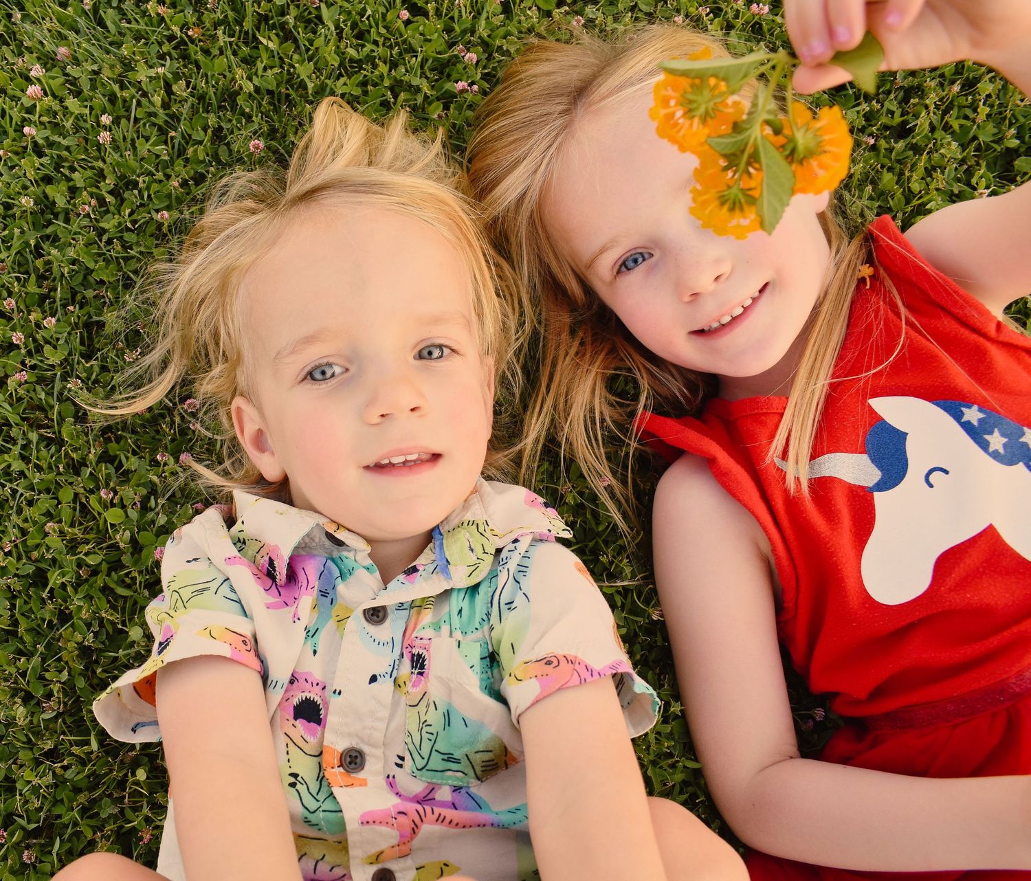 Candid moments captured while playing with orange flowers on grass.