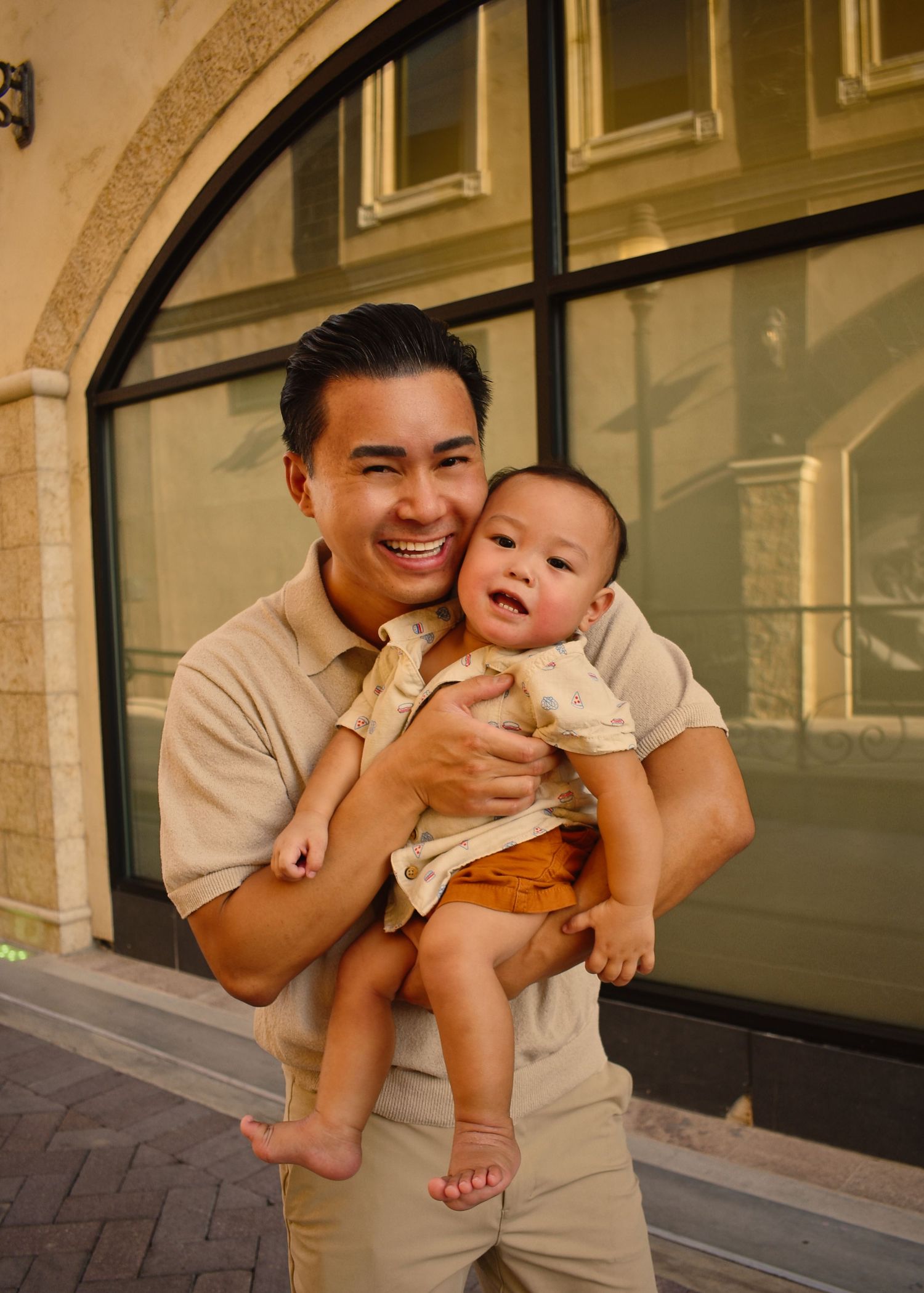 Family enjoying playful moments in front of retail storefronts.