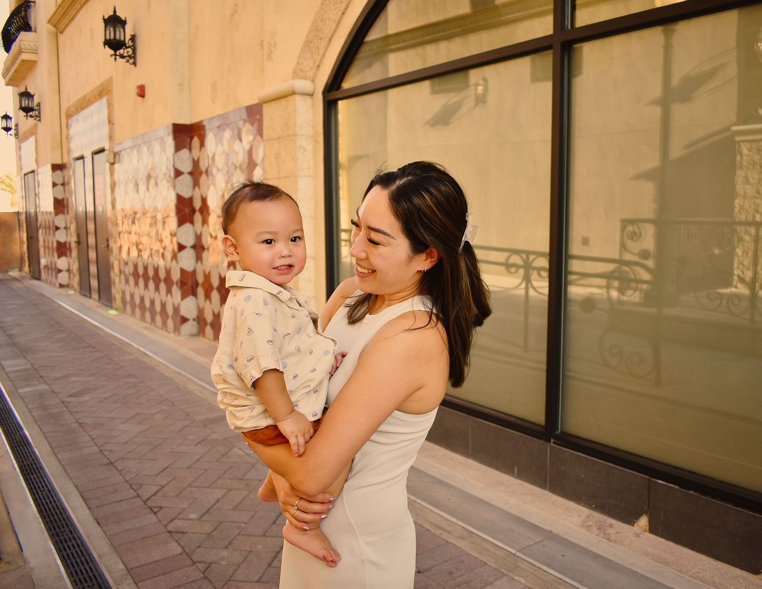 A family shares candid moments together along a building exterior at sunset.