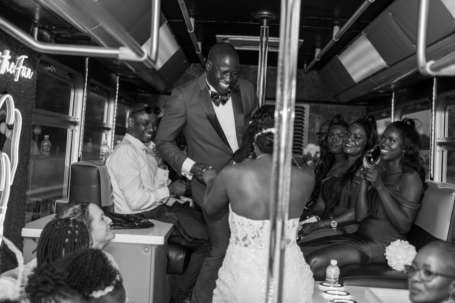 Wedding guests celebrate on what appears to be a party bus or trolley during festivities.
