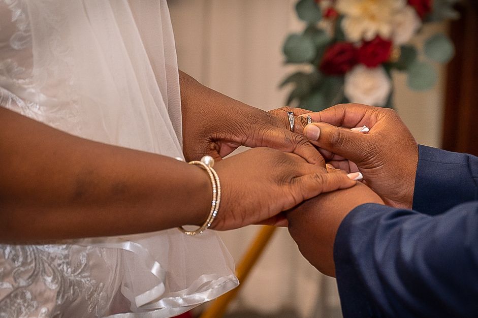 Close-up of hands during the ring exchange ceremony at a wedding.