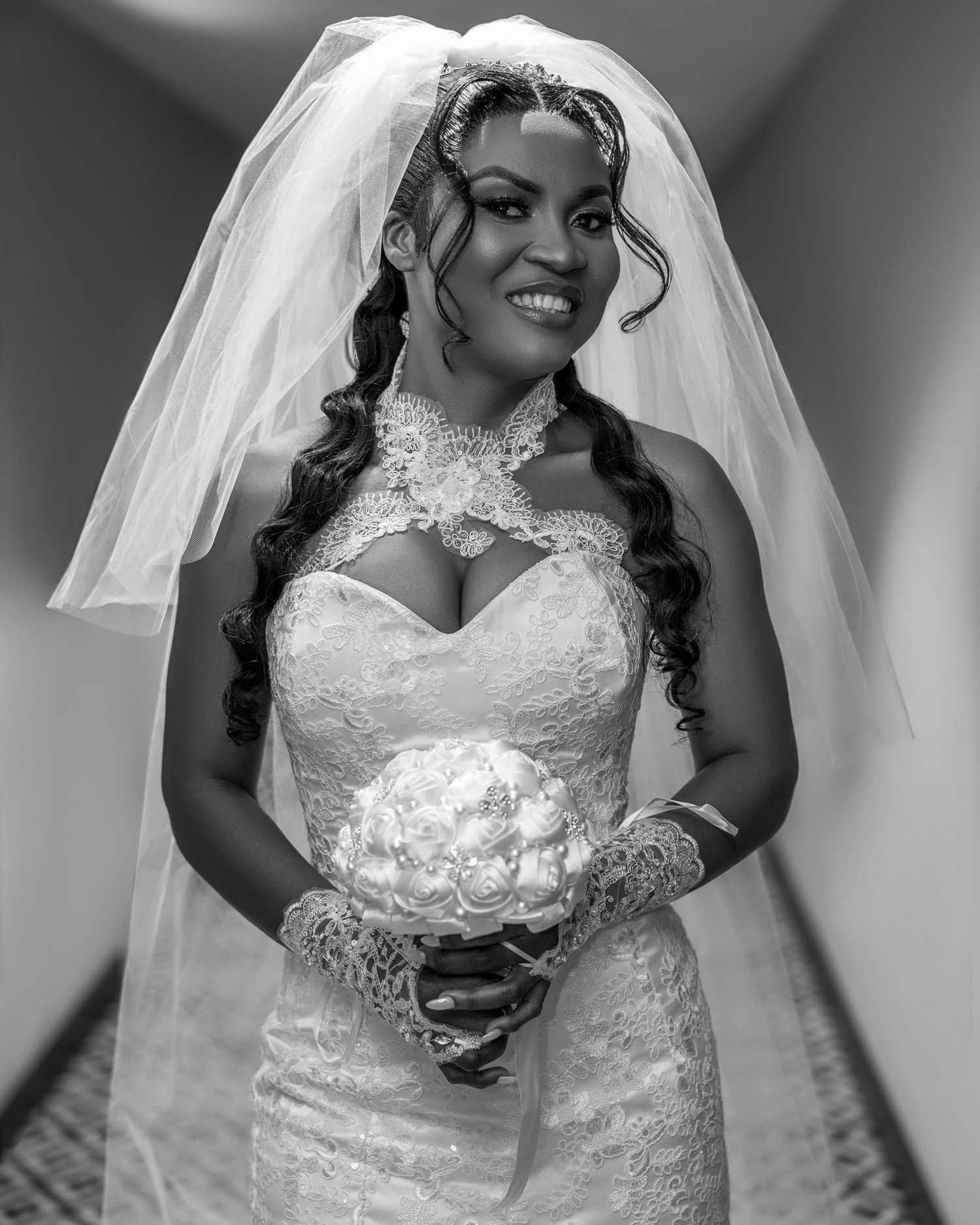 Classic black and white bridal portrait showcasing intricate lace wedding gown and flowing veil.