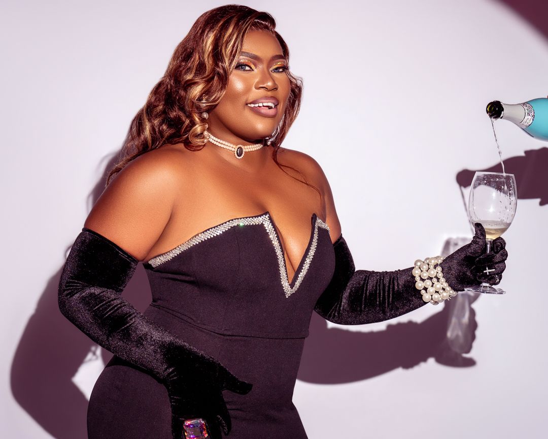 Studio photoshoot with dramatic poses holding champagne glass against white backdrop.