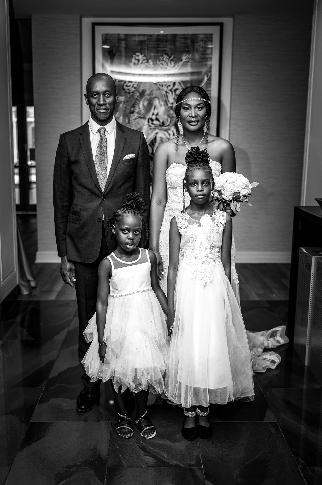 Formal black and white portrait of wedding party in elegant attire.
