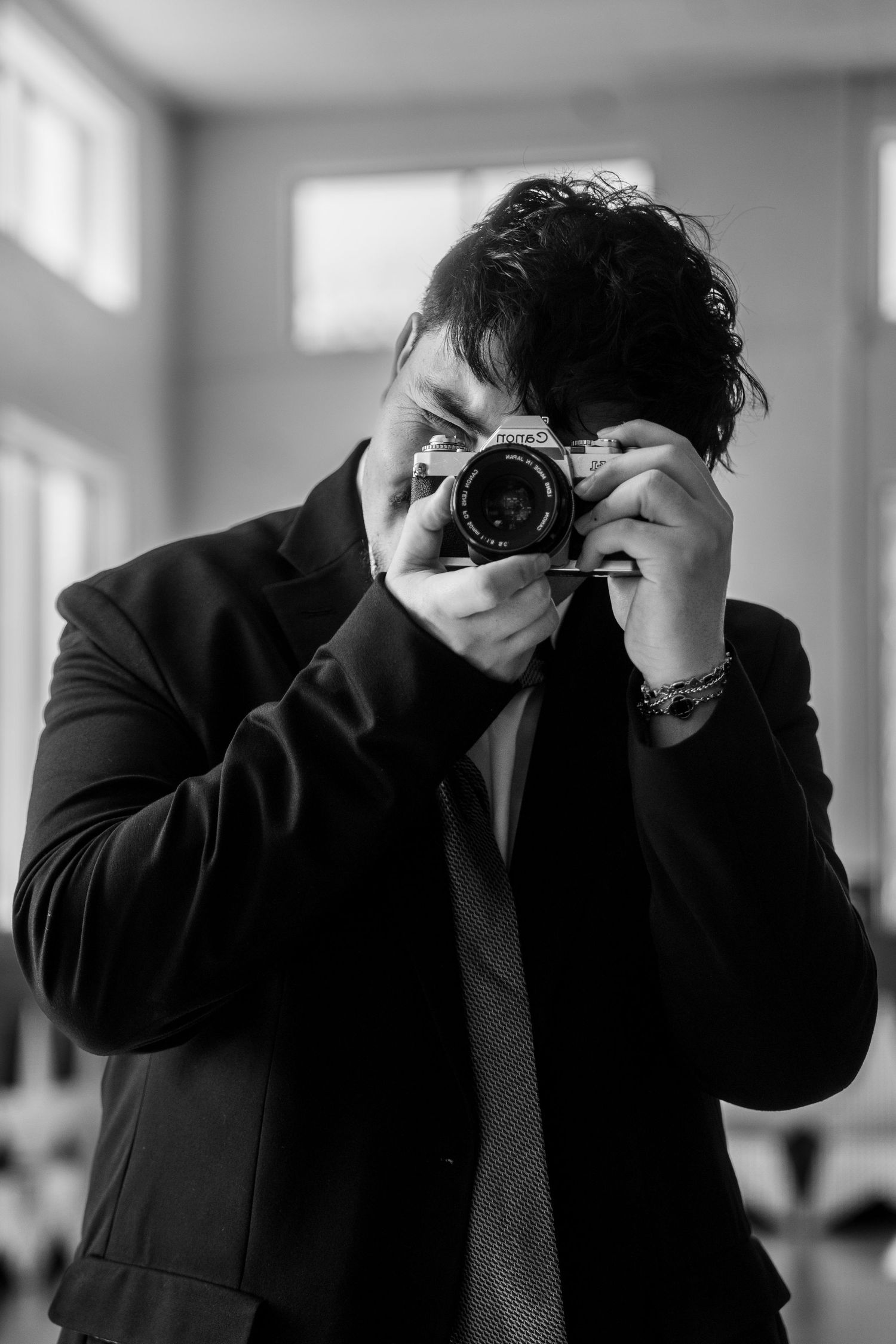 A person in a dark suit holds their head in their hands in a series of black and white photos showing distress.