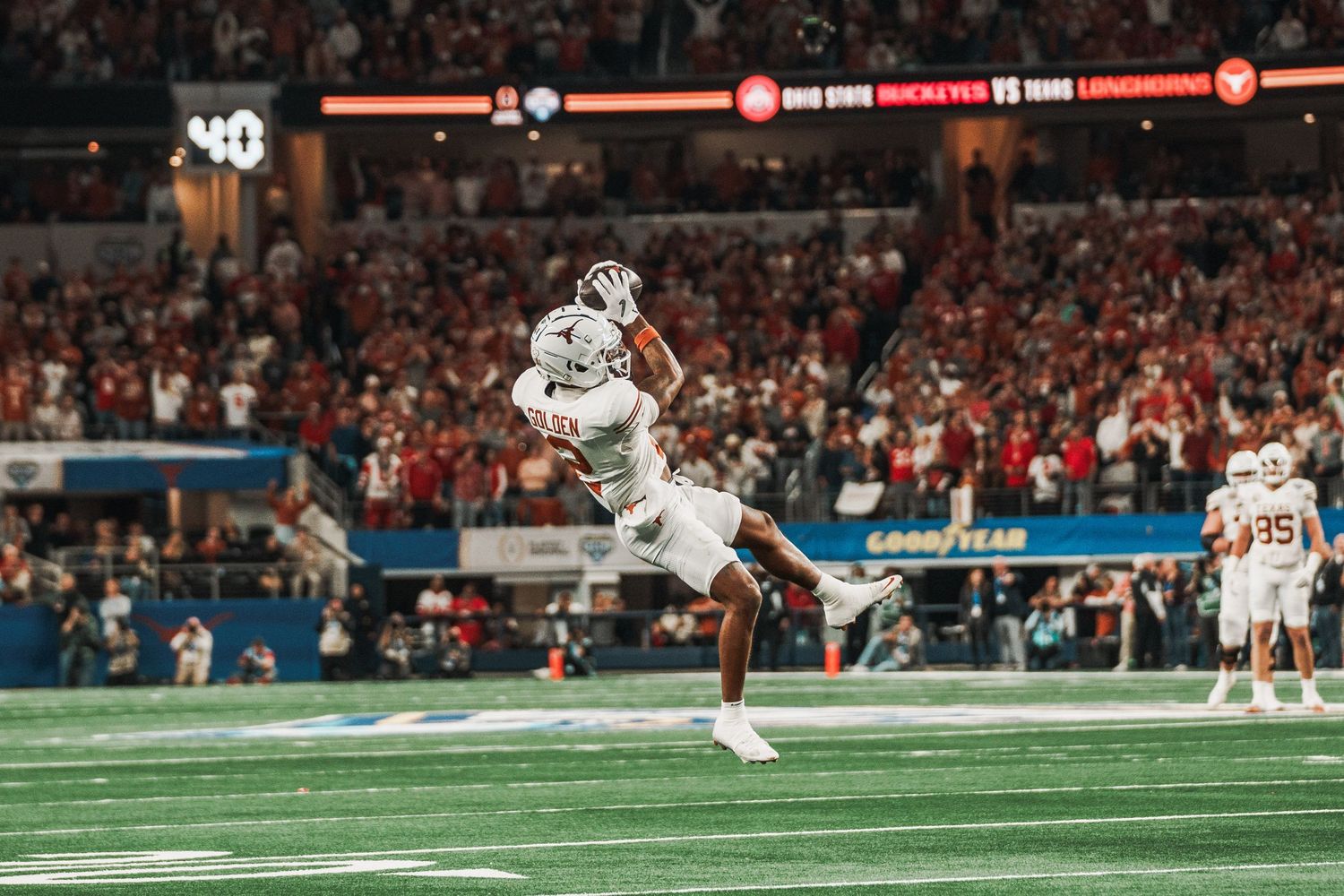 Wide panoramic football action shot showing players in motion during a game.