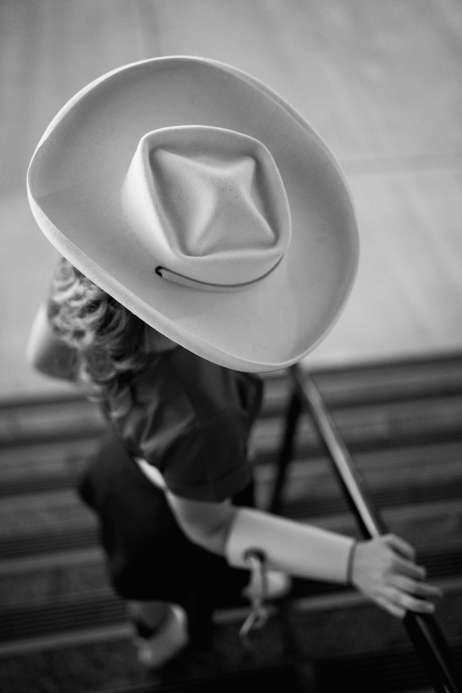 A sequence of black and white photos showing someone playfully spinning and tossing a cowboy hat in motion.