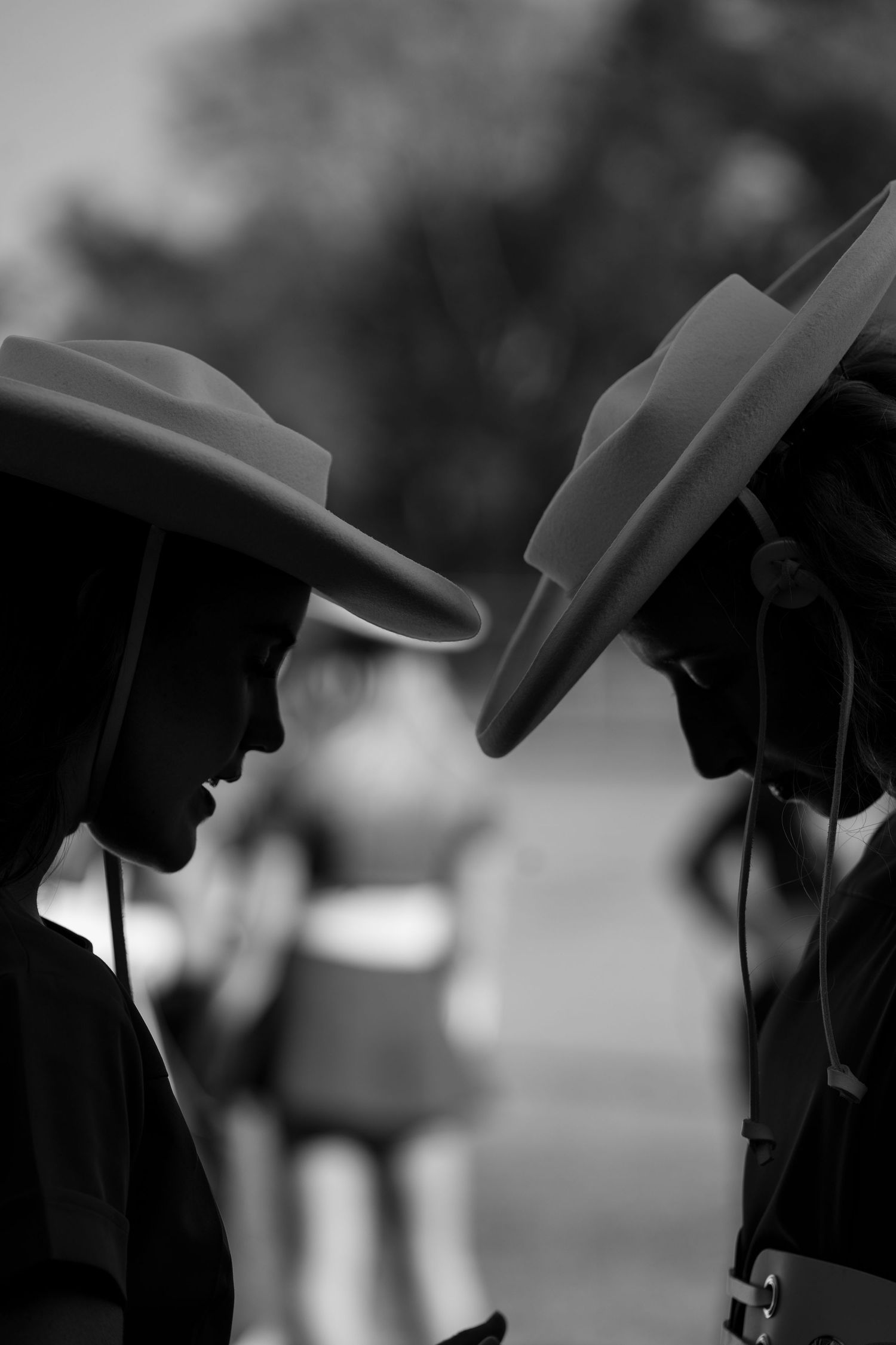 A close-up black and white shot of a security guard's hand holding a police radio or communication device.