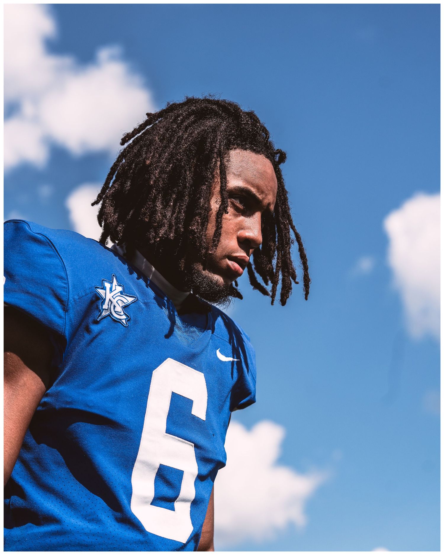 Close-up shot of blue football jerseys against bright blue sky with white clouds.