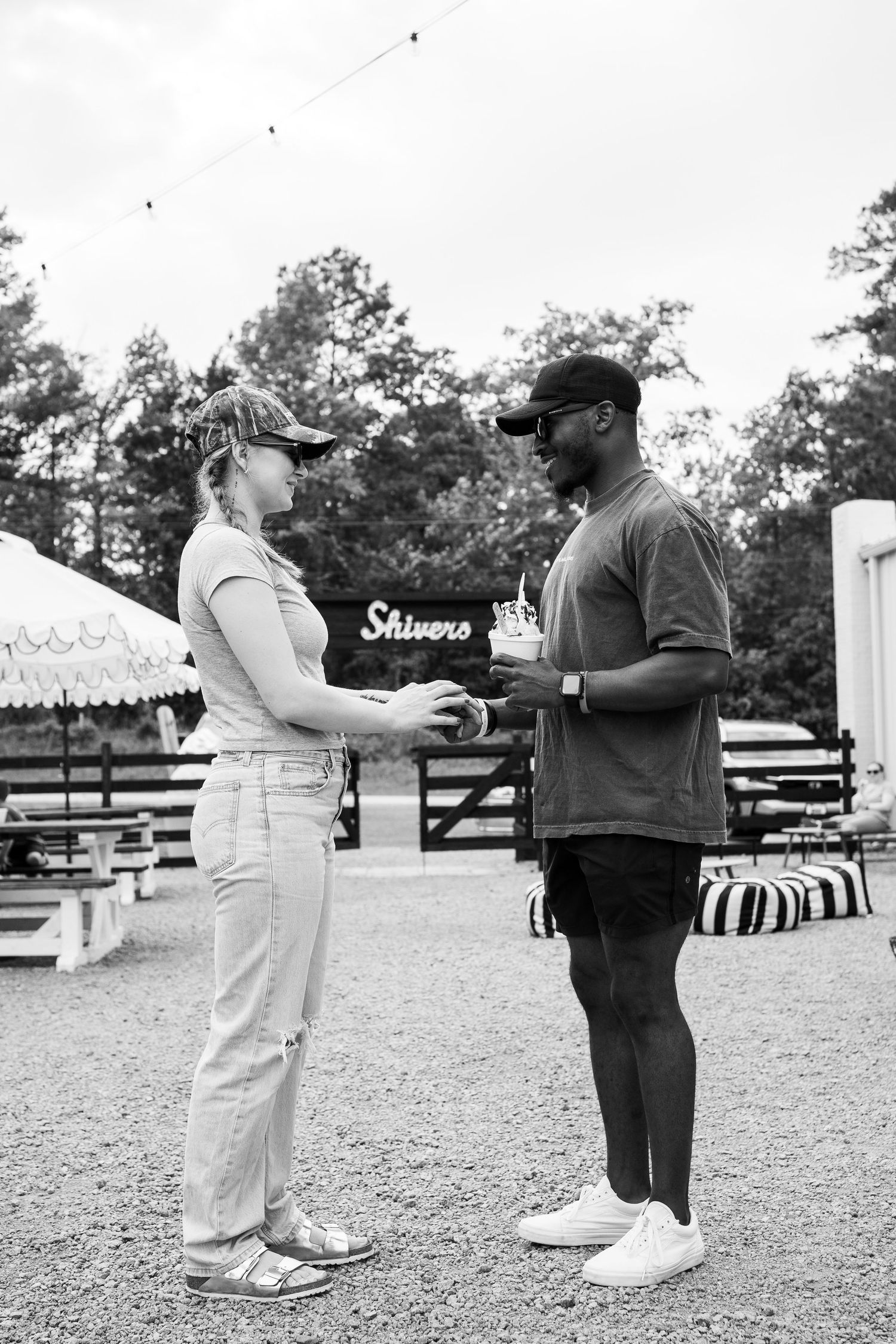Black and white photo of two people having a conversation at an outdoor event.
