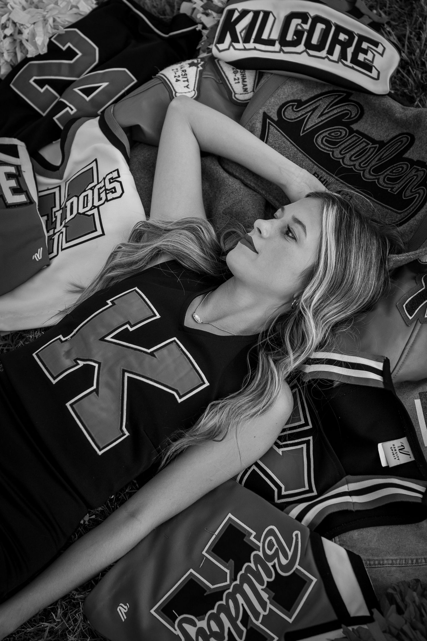 Black and white senior photo with athletic jerseys and Kilgore school spirit wear.