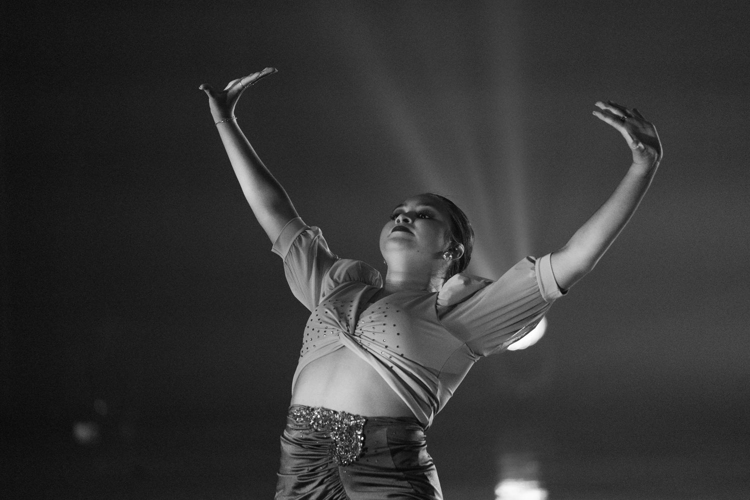 Black and white photos capture a contemporary dance performance with dramatic lighting and expressive movements.